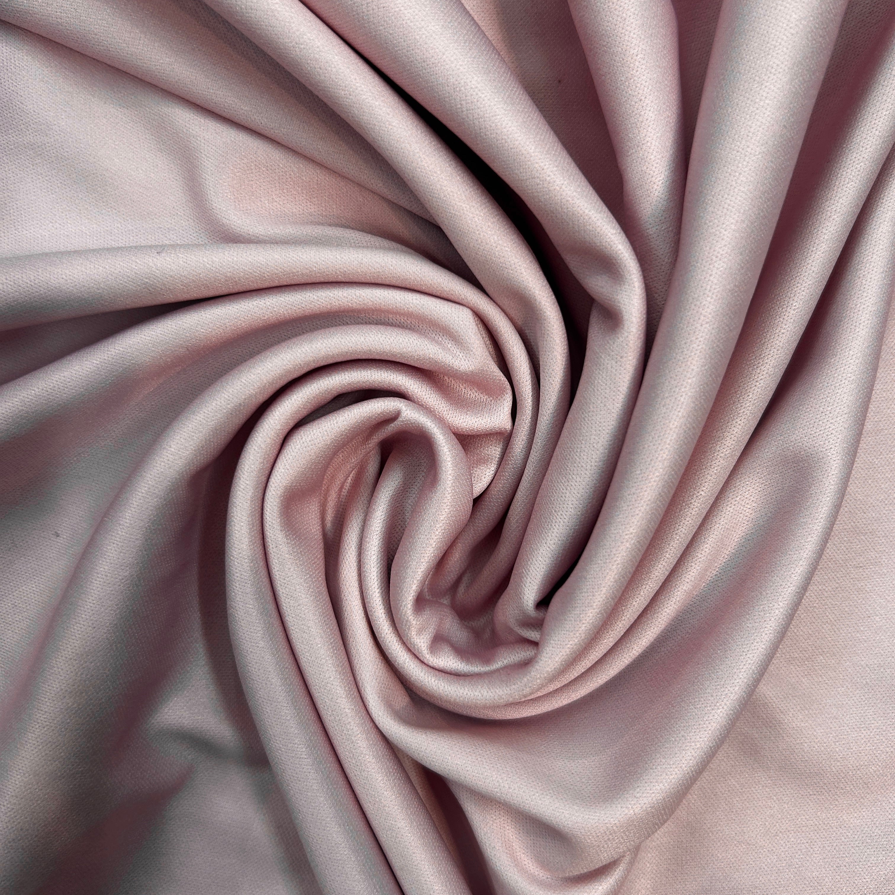 Close-up of pink satin fabric with folds