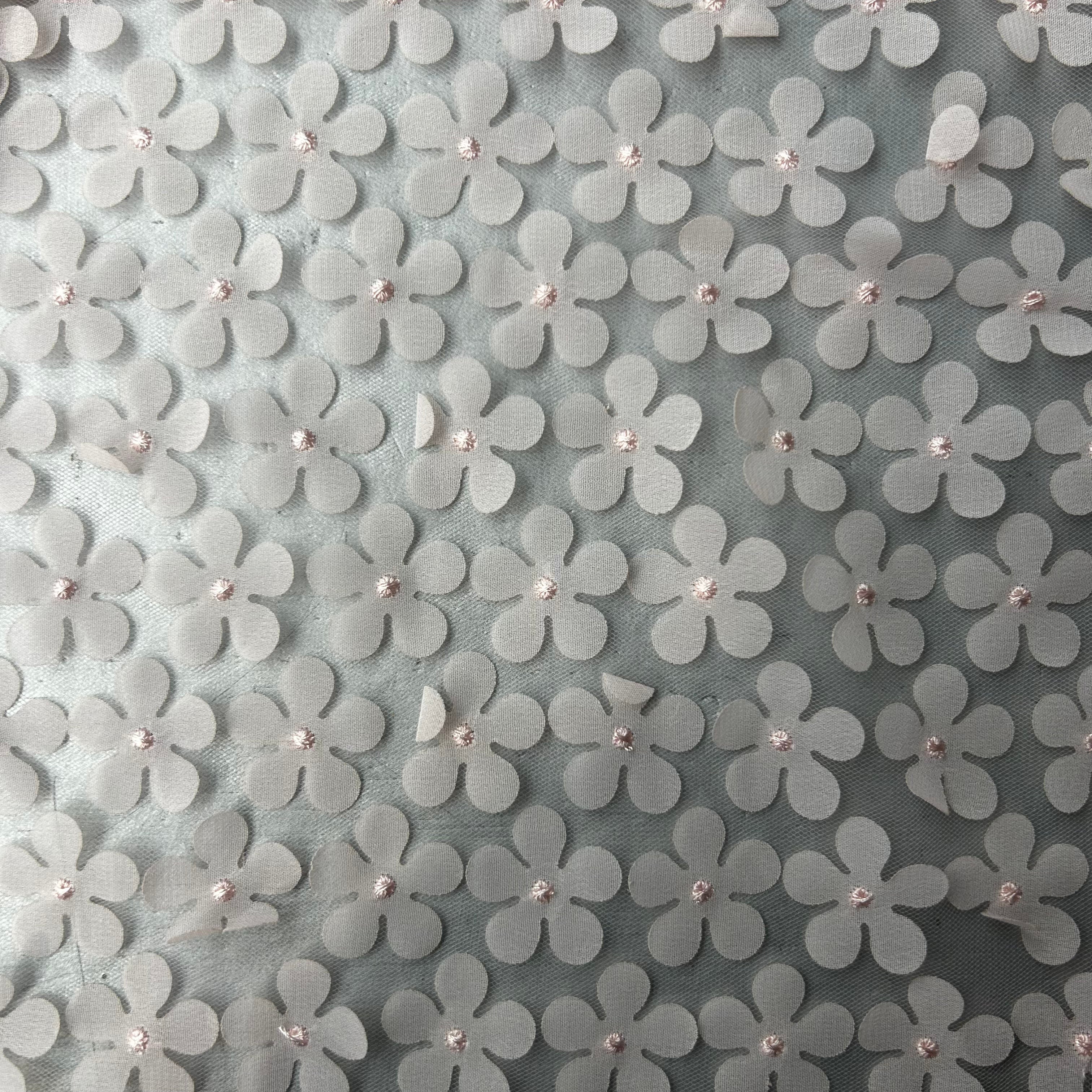 Pattern of white flowers with small embellishments on a gray background