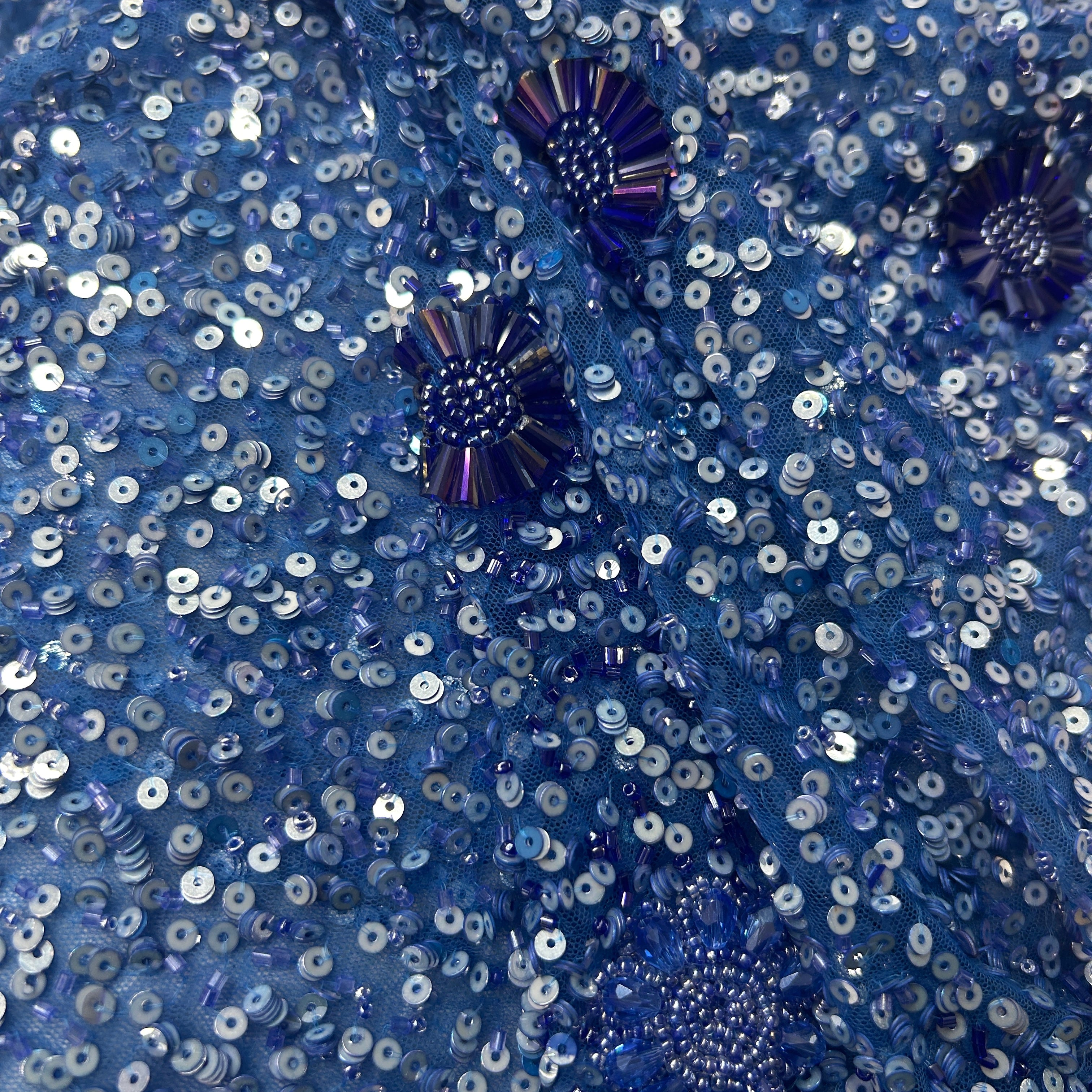 Close-up of blue sequin fabric with decorative elements