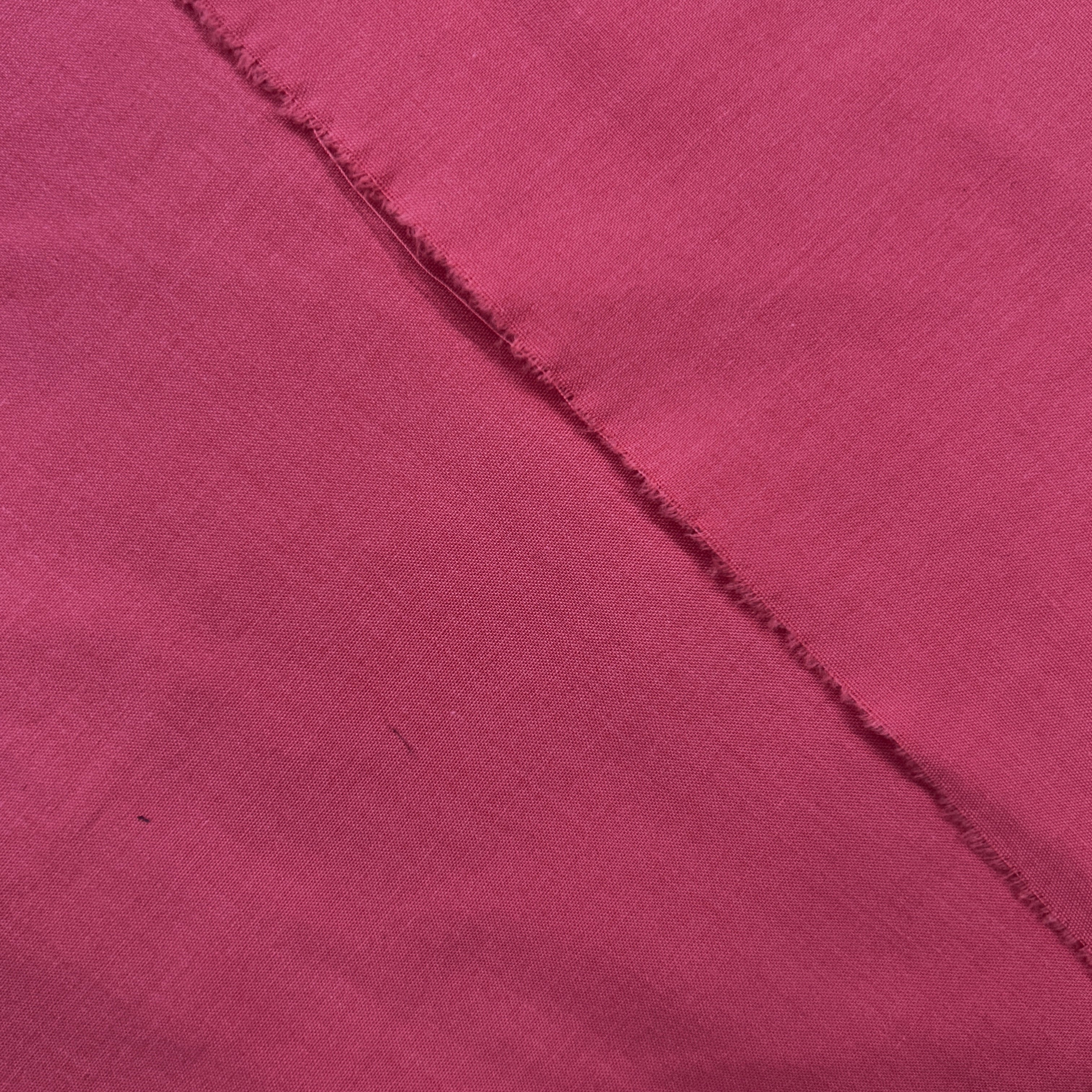 Close-up of a maroon fabric with a diagonal seam