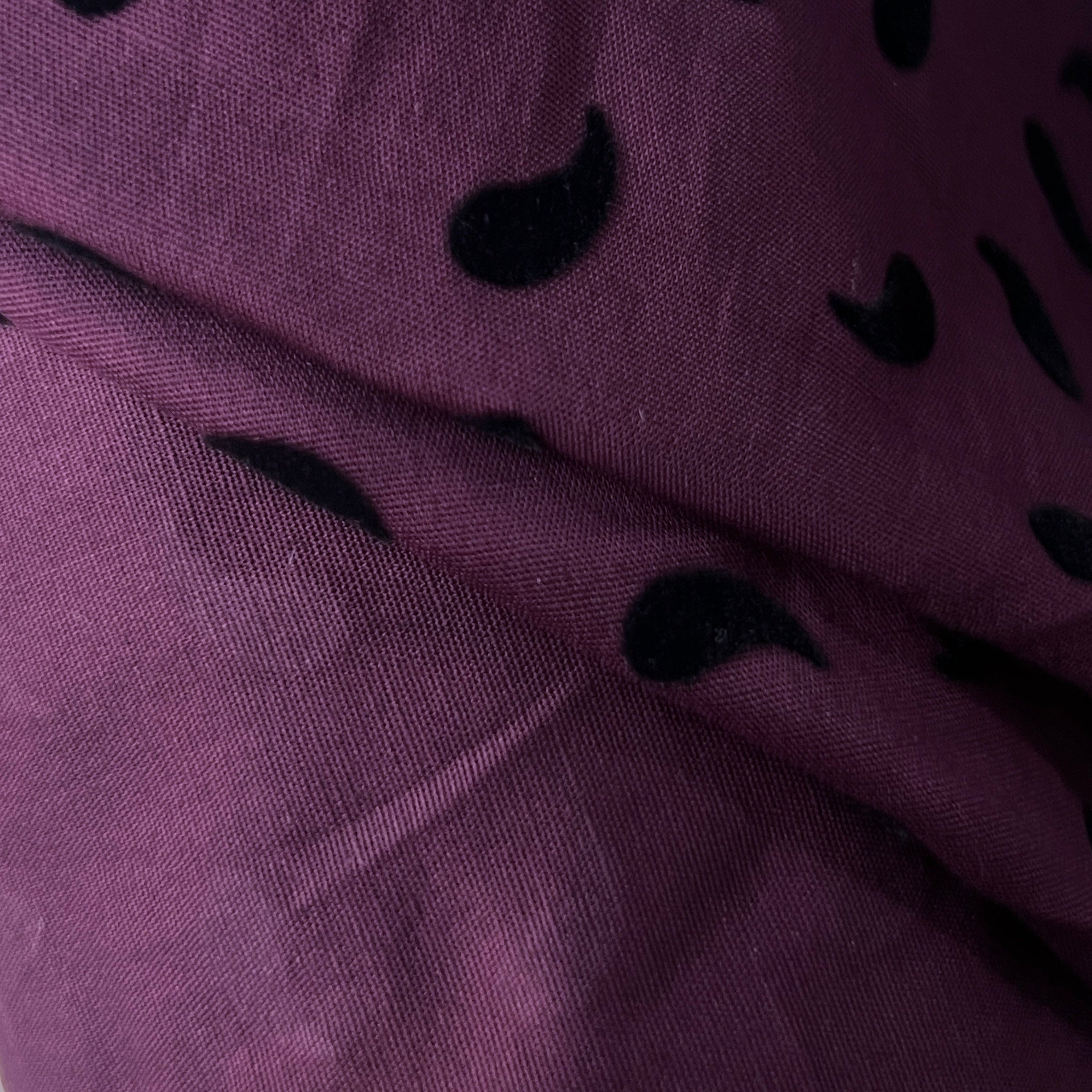 Close-up of purple fabric with black abstract shapes
