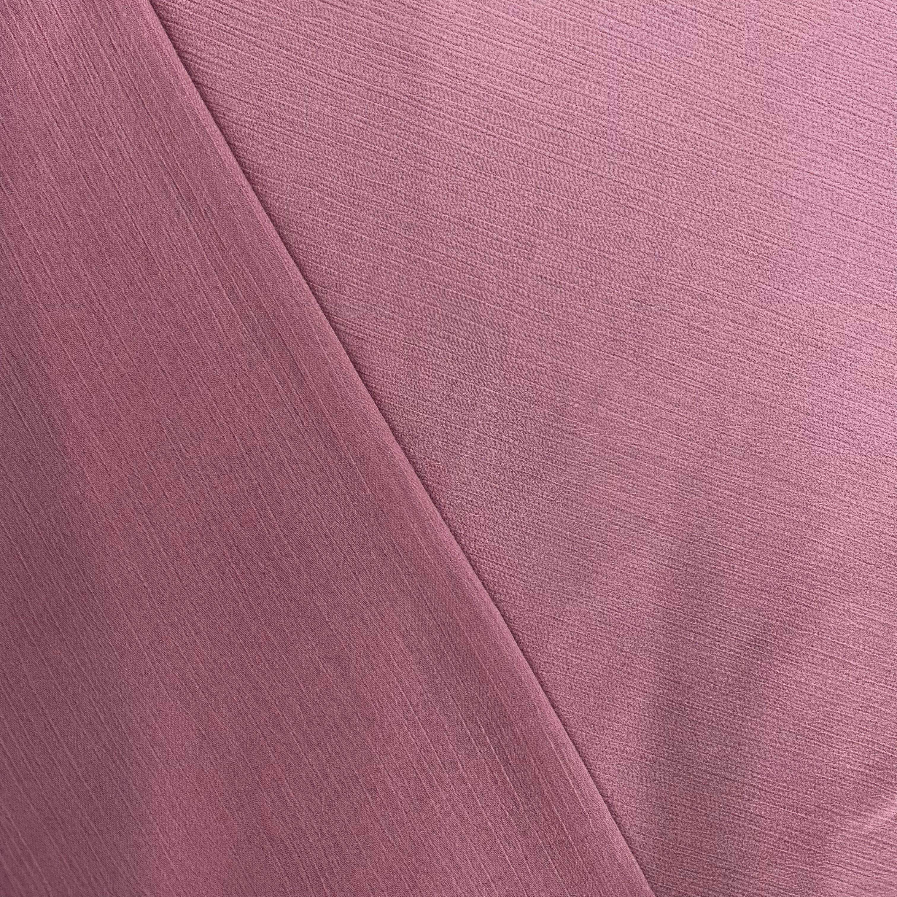 Close-up of a pink fabric with a diagonal crease