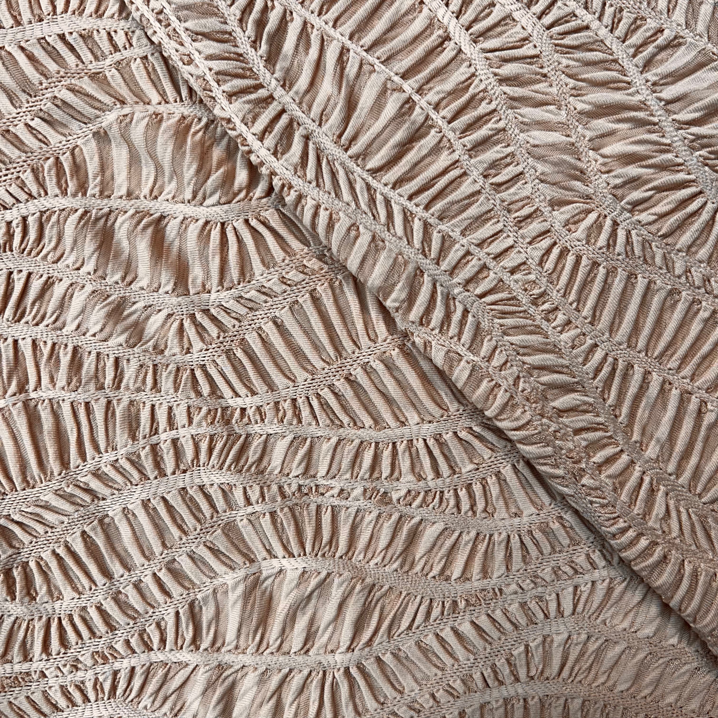 Close-up of textured beige fabric with a diamond pattern