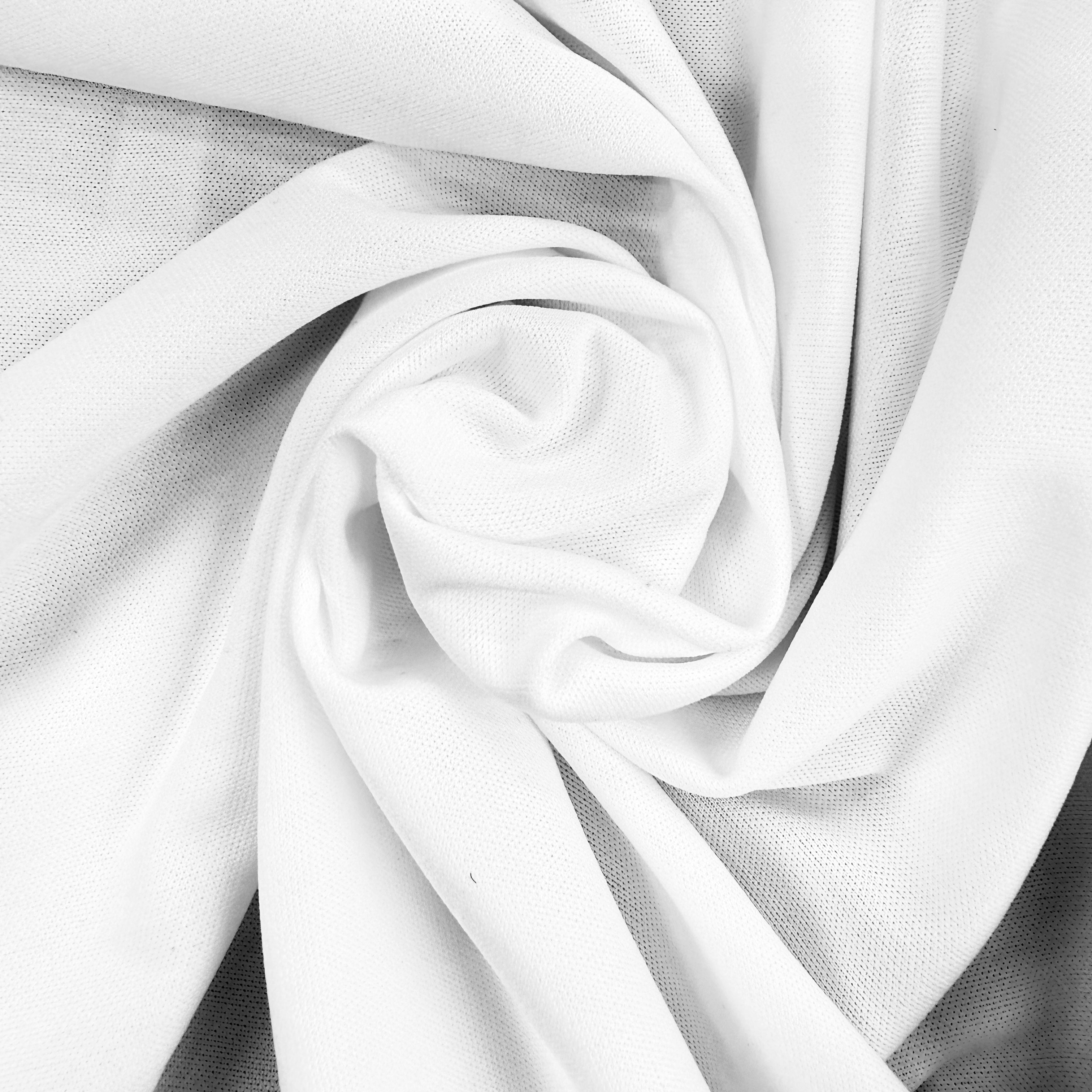 A close-up of white fabric arranged in a spiral drape, showing the material texture and soft folds.