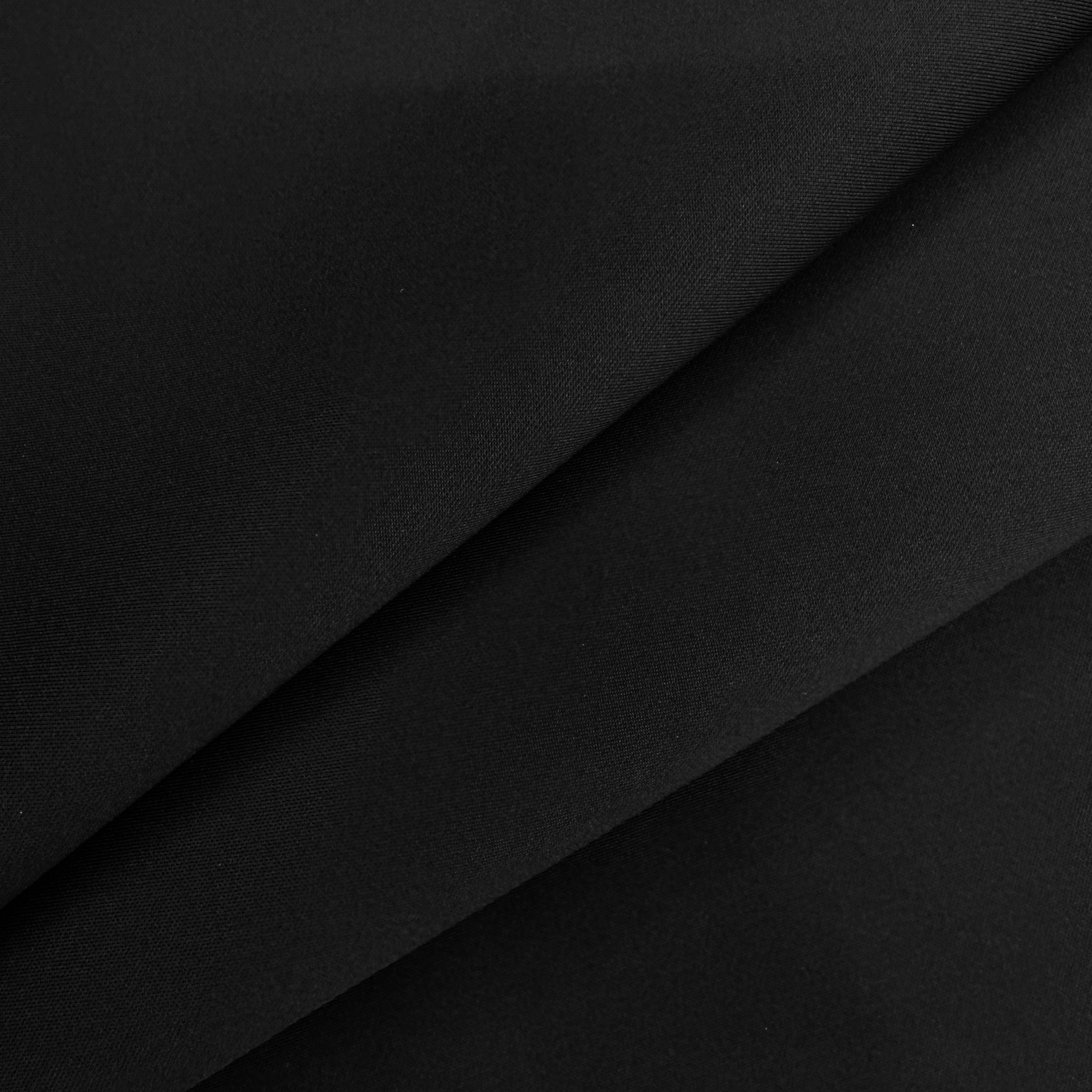 A close-up of black fabric with soft diagonal folds showing its smooth texture.