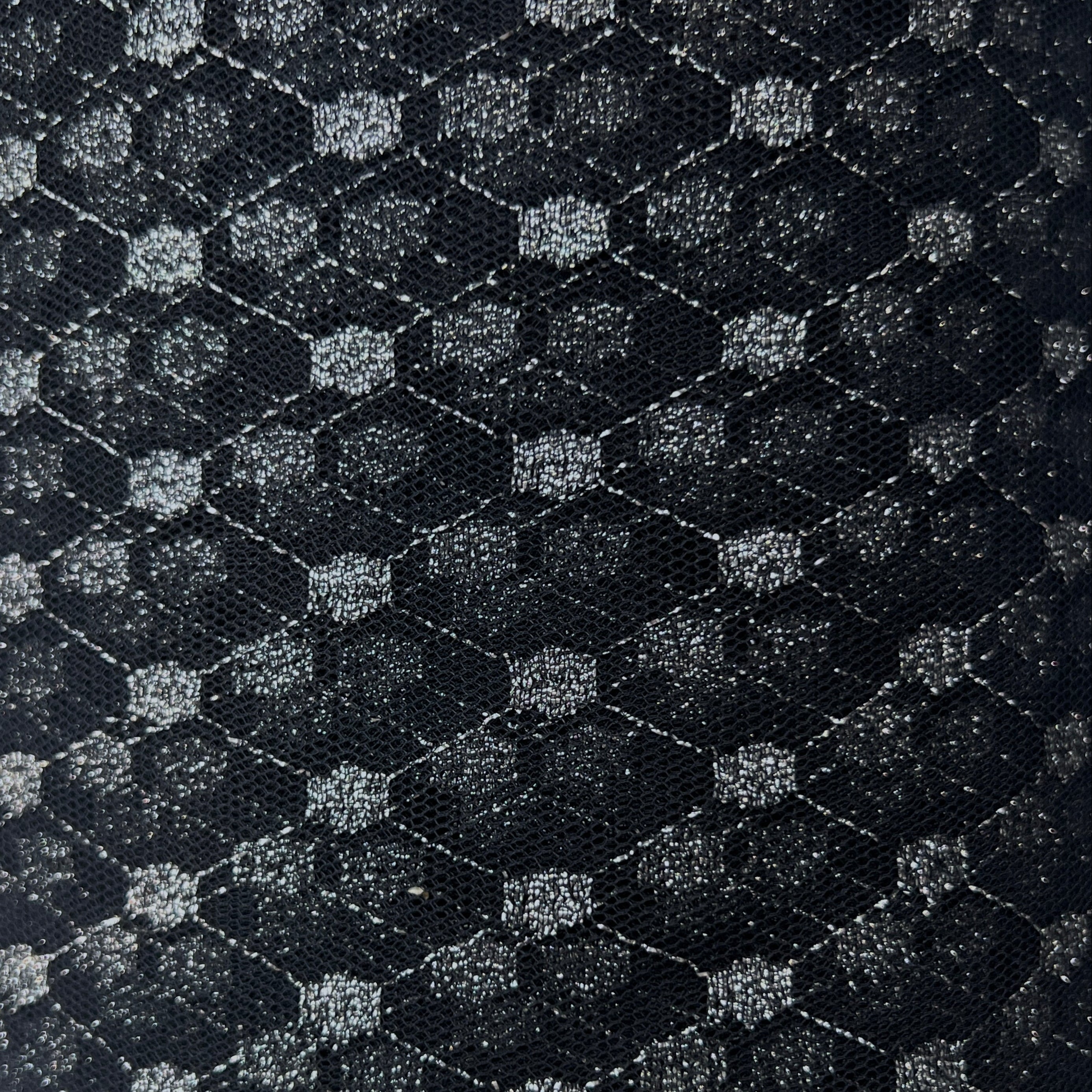 Close-up of a textured black and gray fabric with geometric pattern