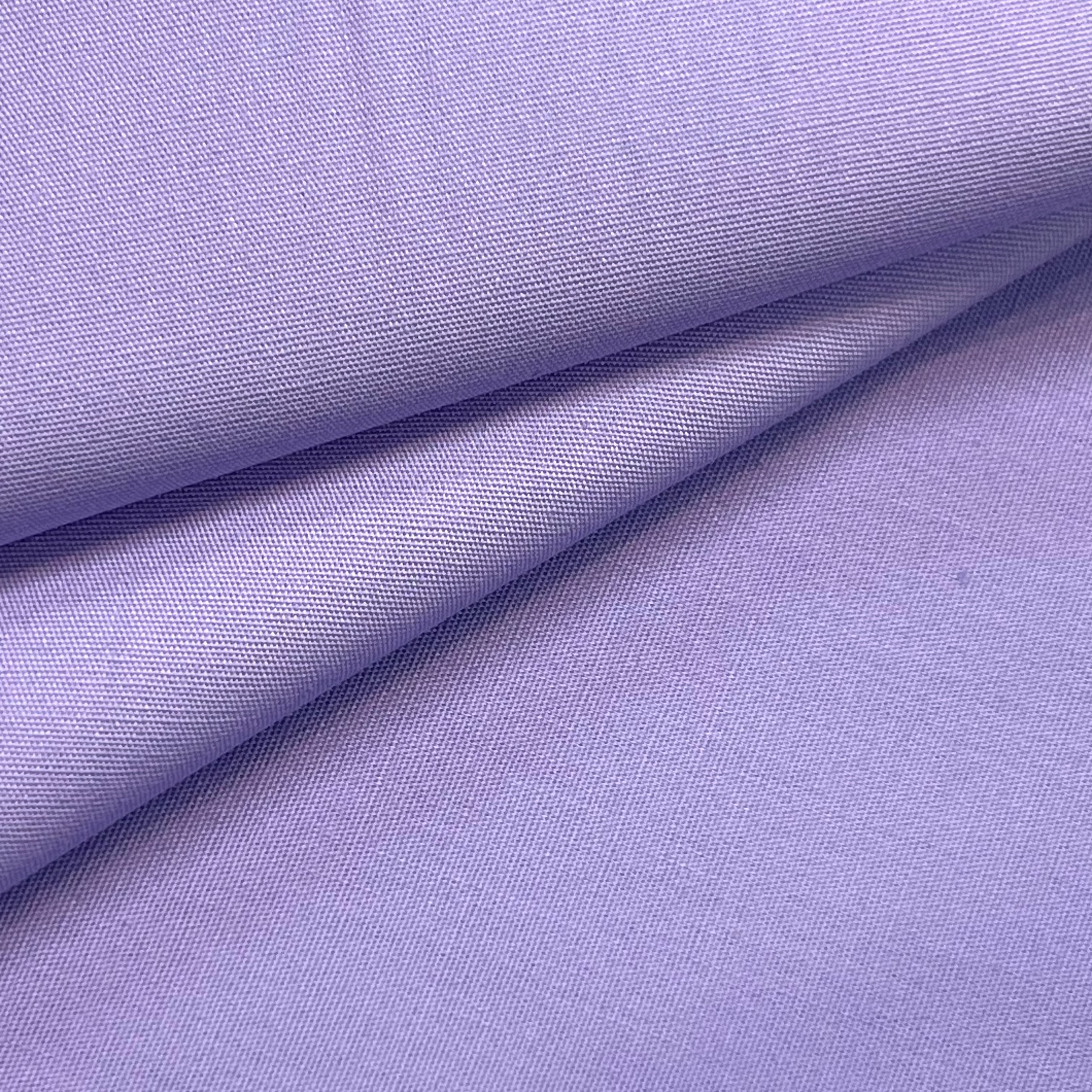 A close-up of a folded lavender cotton poplin fabric.