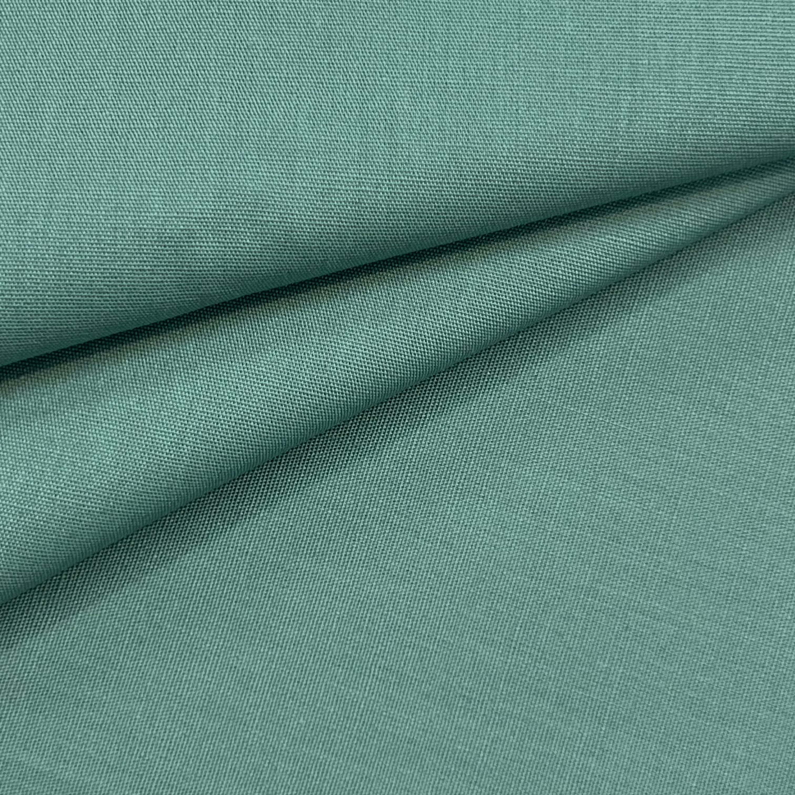 A close-up of teal cotton poplin fabric with a visible weave.