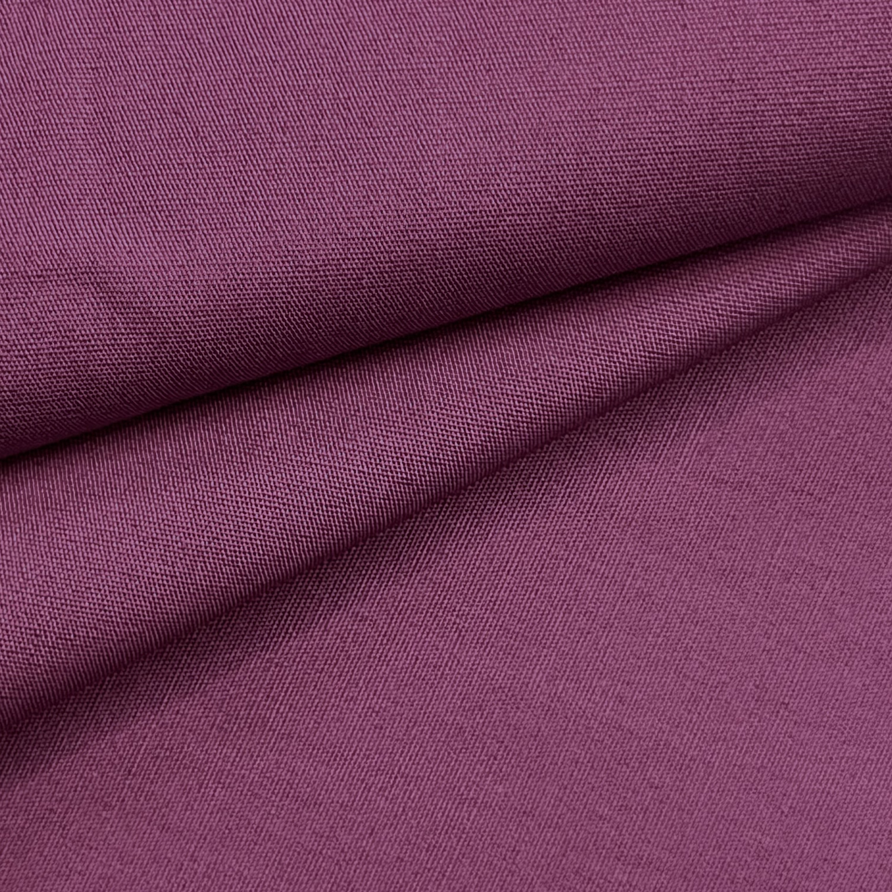 A close-up of smooth, plum-colored cotton poplin fabric with a fine, crisp weave.