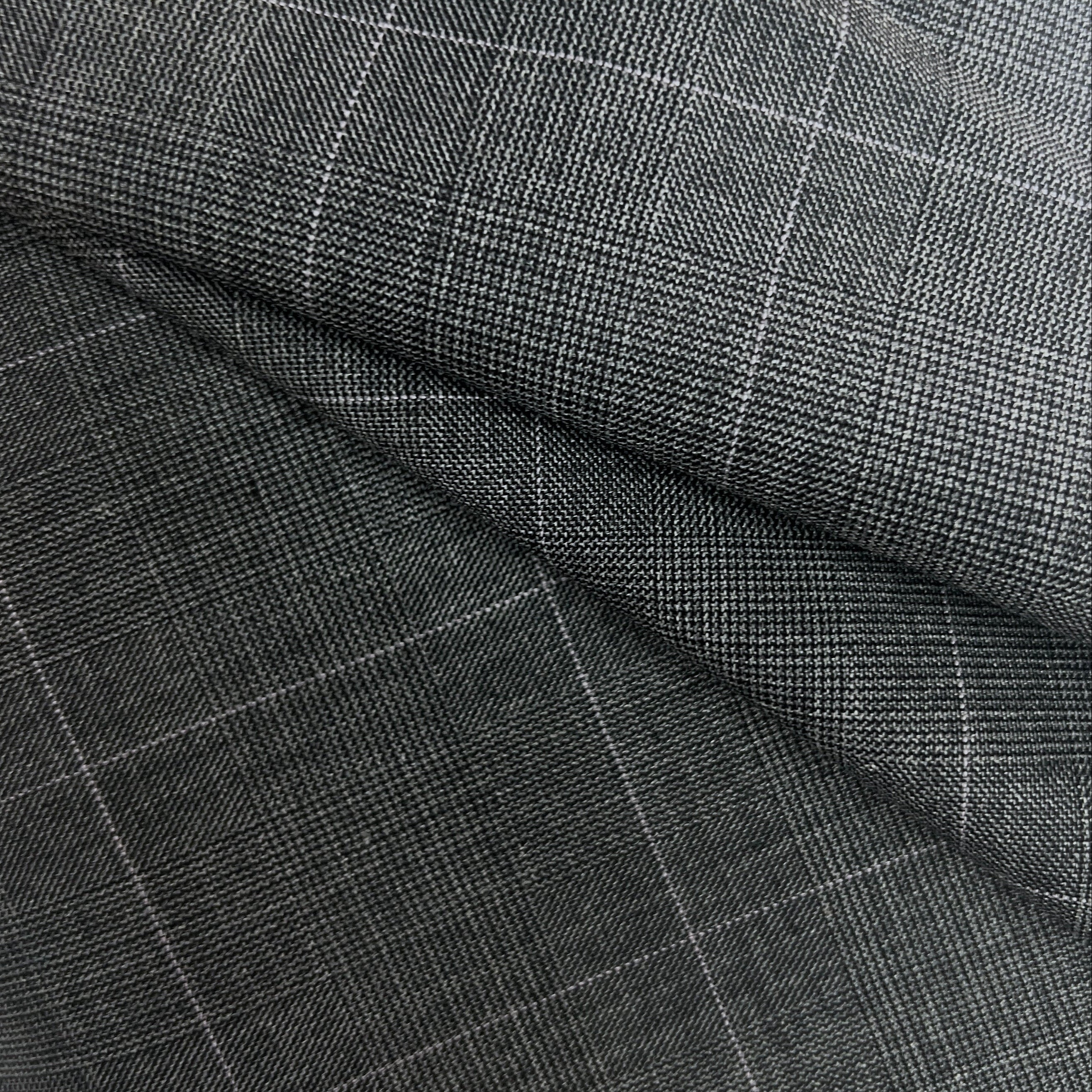 A close-up of dark charcoal gray fabric with a fine white windowpane plaid pattern, shown with soft folds.