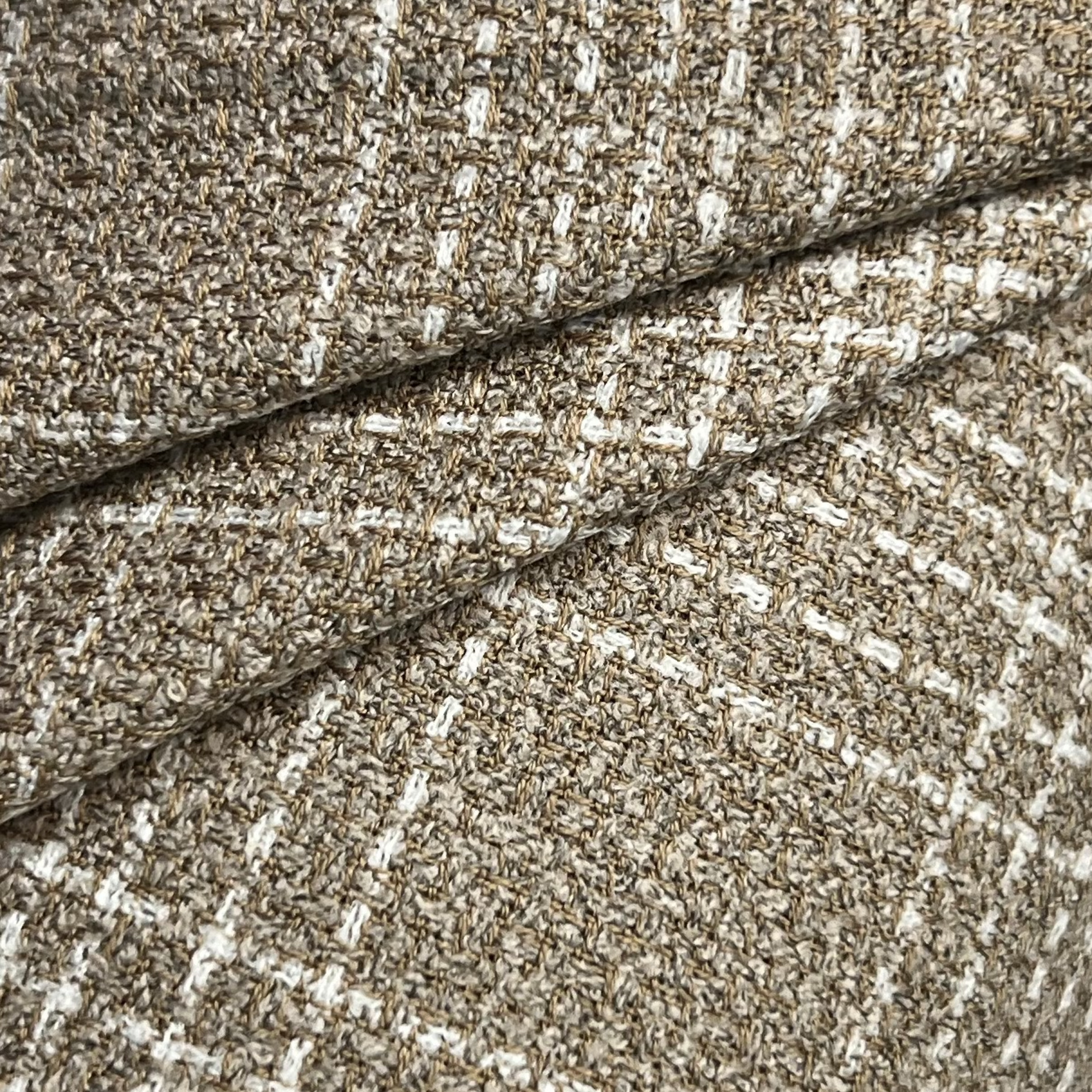 Close-up of beige virgin wool and silk tweed fabric with a textured weave and white grid pattern.