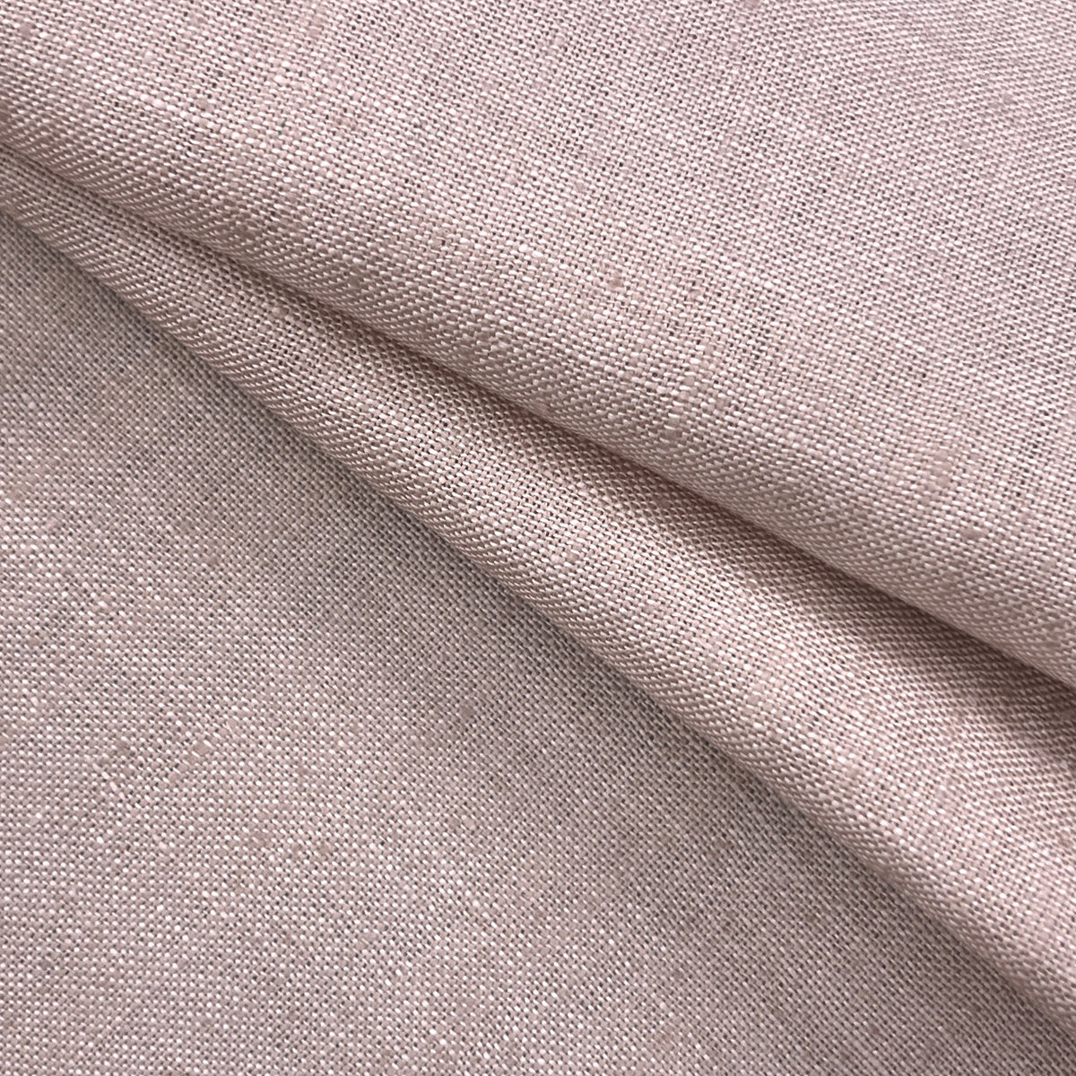 A close-up of draped woven fabric in a soft dusty blush pink color, showing the texture and weave detail.
