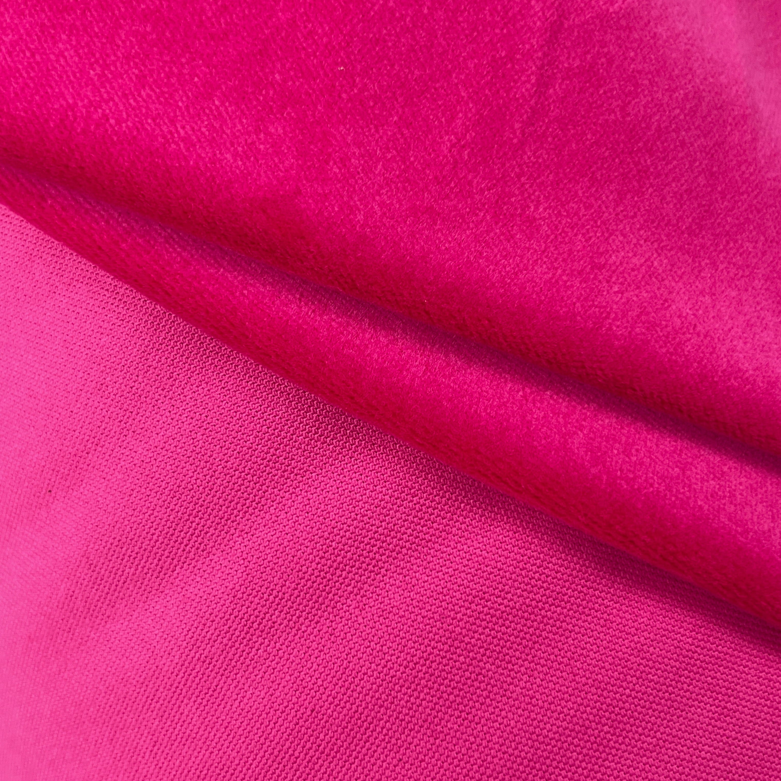 A close-up of bright pink fabric with a soft, slightly sheer texture and gentle folds.