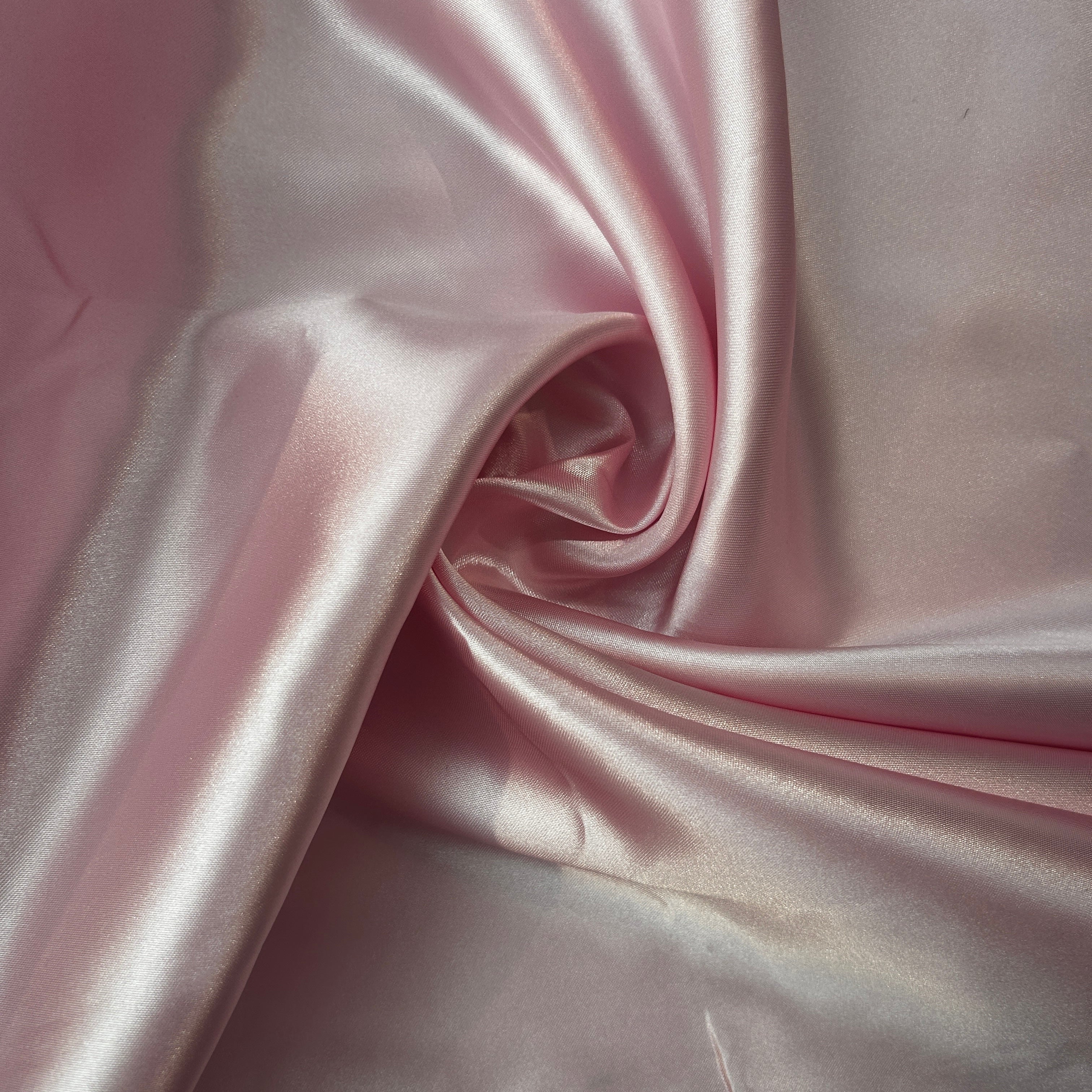 Close-up of pink satin fabric with folds