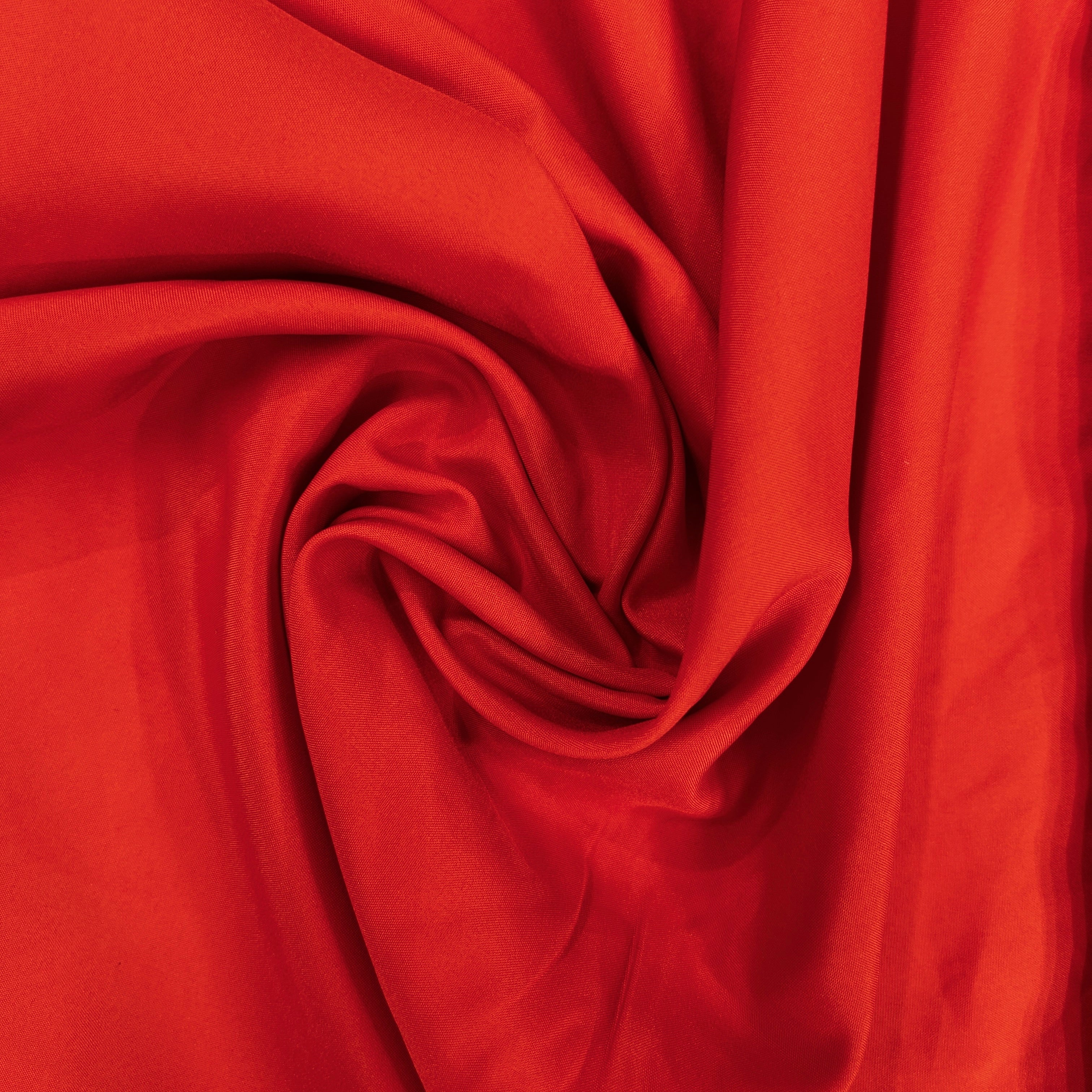 Red mechanical stretch polyester fabric swirled into a circular drape pattern.