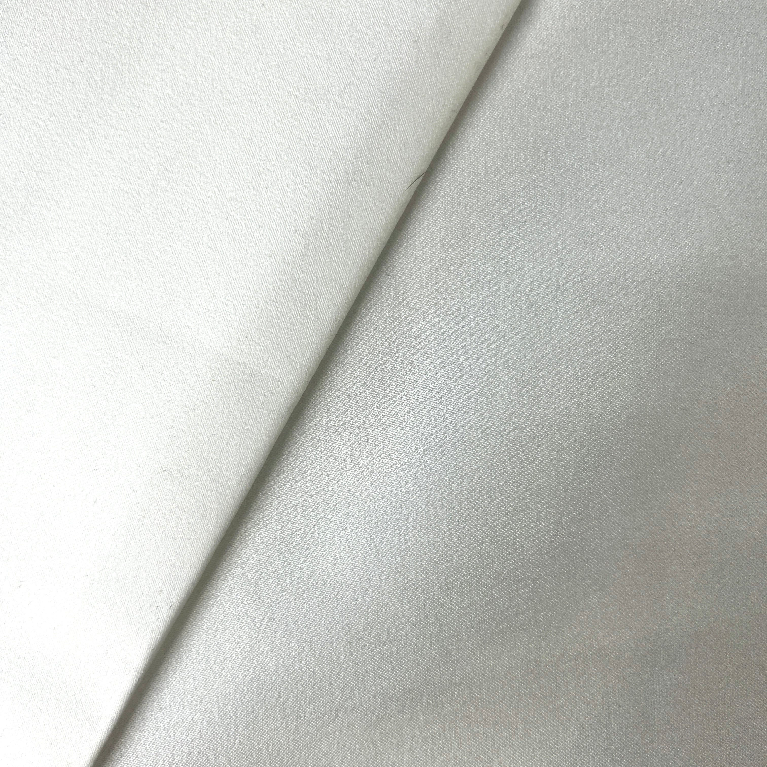 Close-up of a folded fabric with a subtle pattern on a light gray background