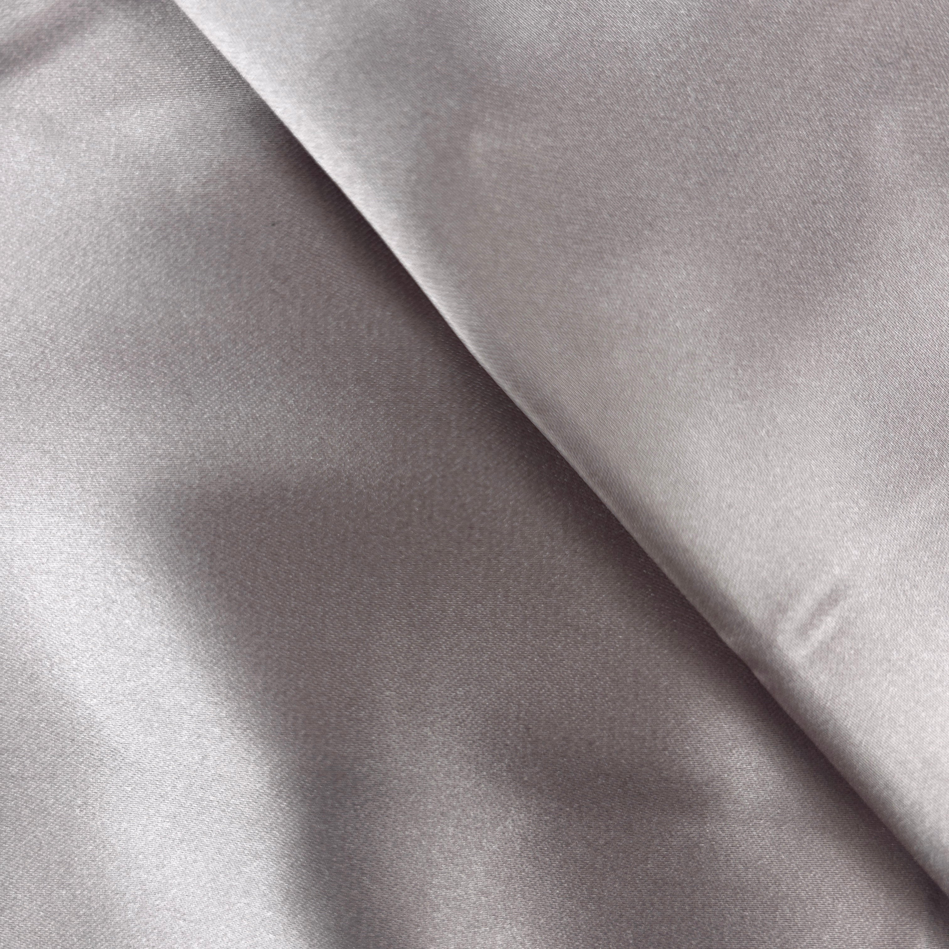 A close-up of draped light gray fabric with a soft satin-like sheen and subtle texture.