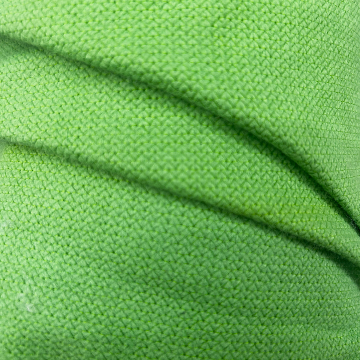 Close-up of vibrant green thick interfacing knit apparel fabric with a textured weave pattern.