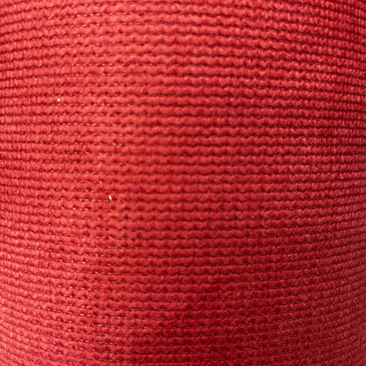 Close-up of red and green thick interfacing knit apparel fabric with a textured ribbed pattern.