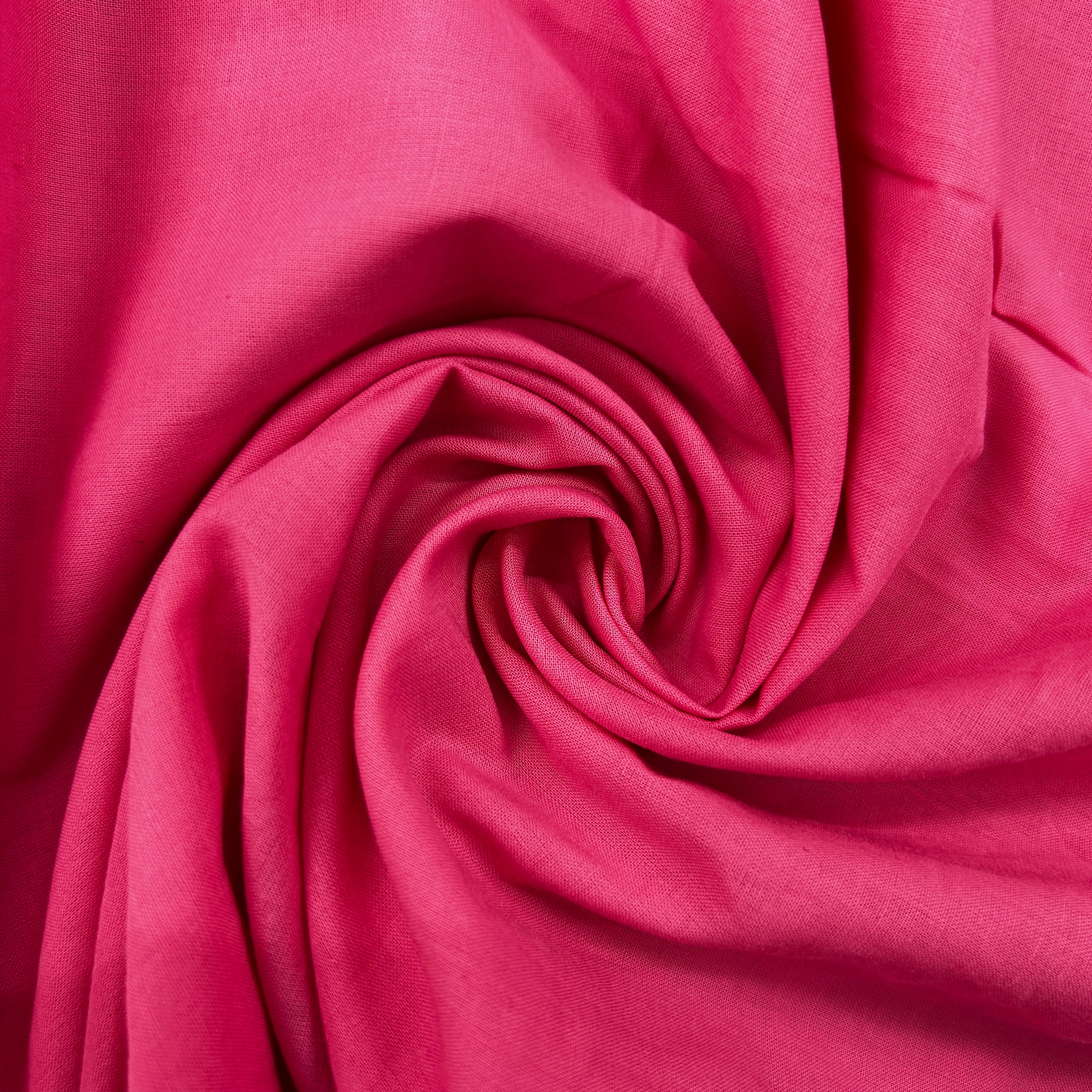 A close-up of draped pink fabric arranged in a spiral, showing the material's texture and color.