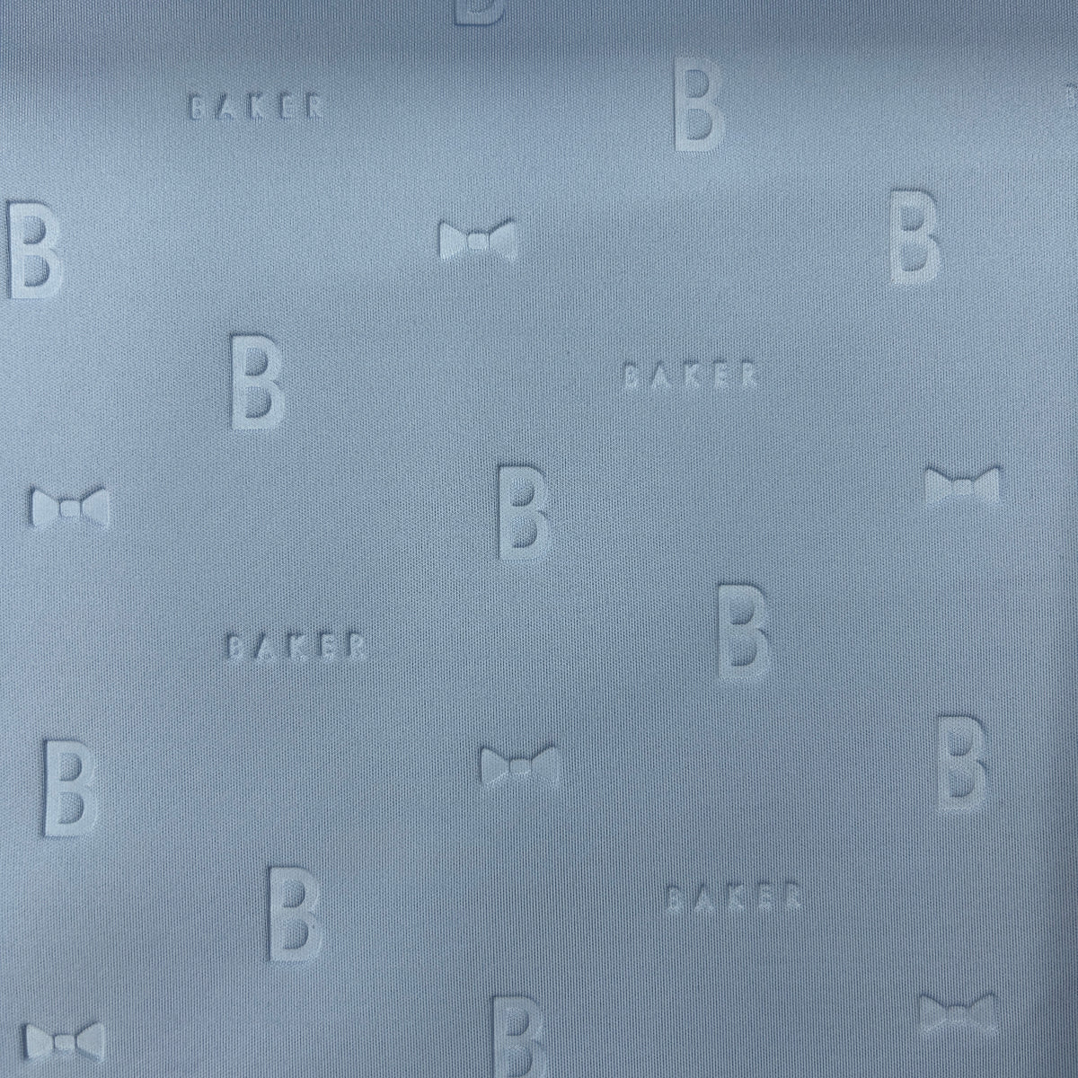 Close-up of light blue 3D Ted Baker scuba jersey fabric with embossed B, Baker, and bow patterns.