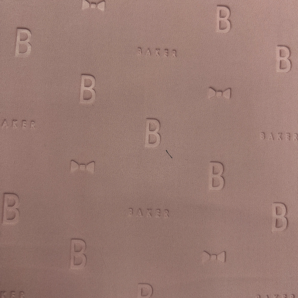 Close-up of mauve 3D Ted Baker thick scuba jersey fabric with embossed 'B' and 'BAKER' logo pattern.