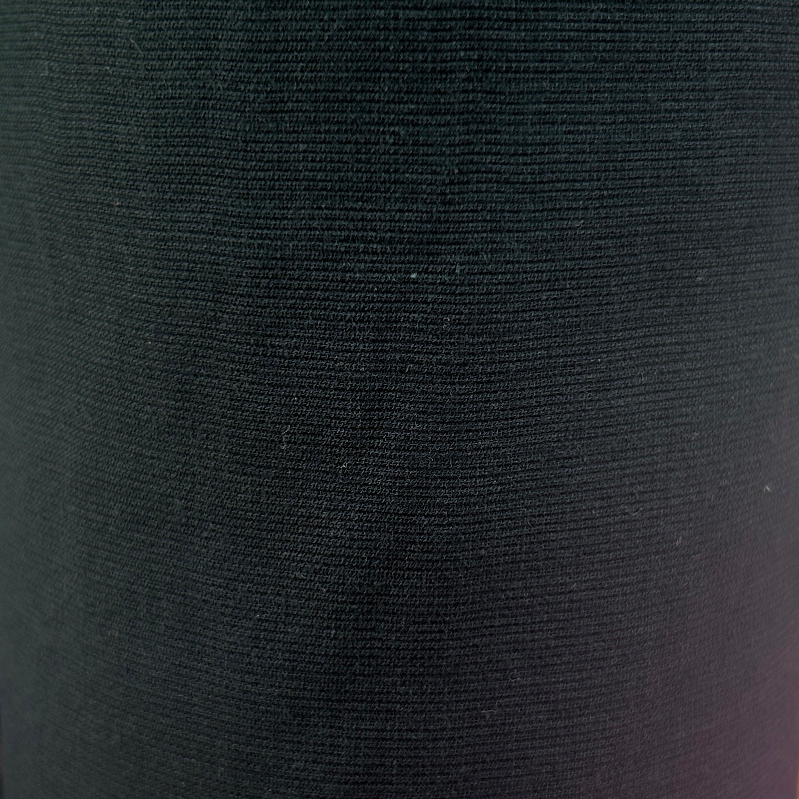 A close-up of a dark charcoal gray ribbed knit fabric texture.