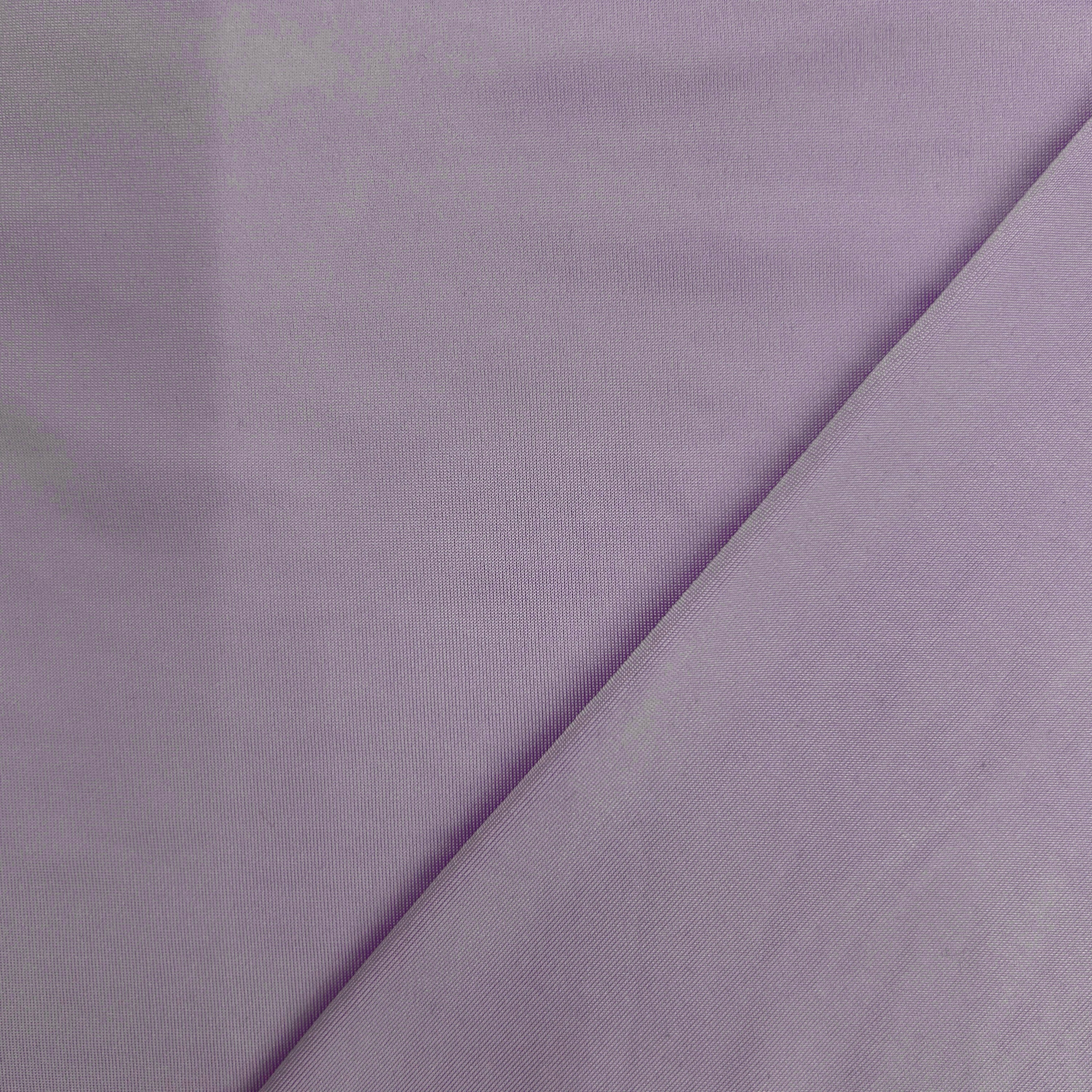 A close-up of light lavender purple fabric with a diagonal fold running across the frame.