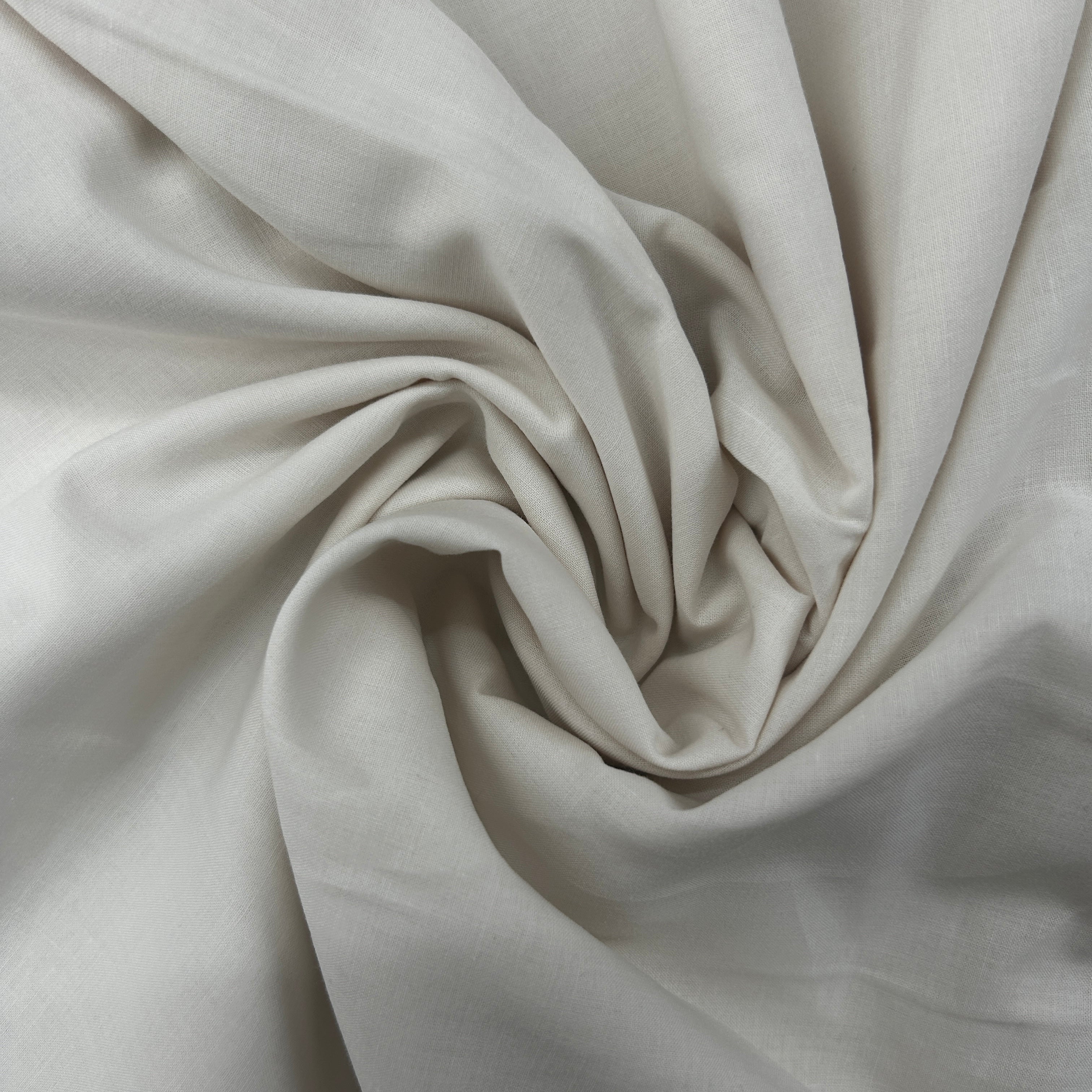 A close-up of draped off-white fabric with soft folds and a subtle sheen, arranged in a spiral pattern.