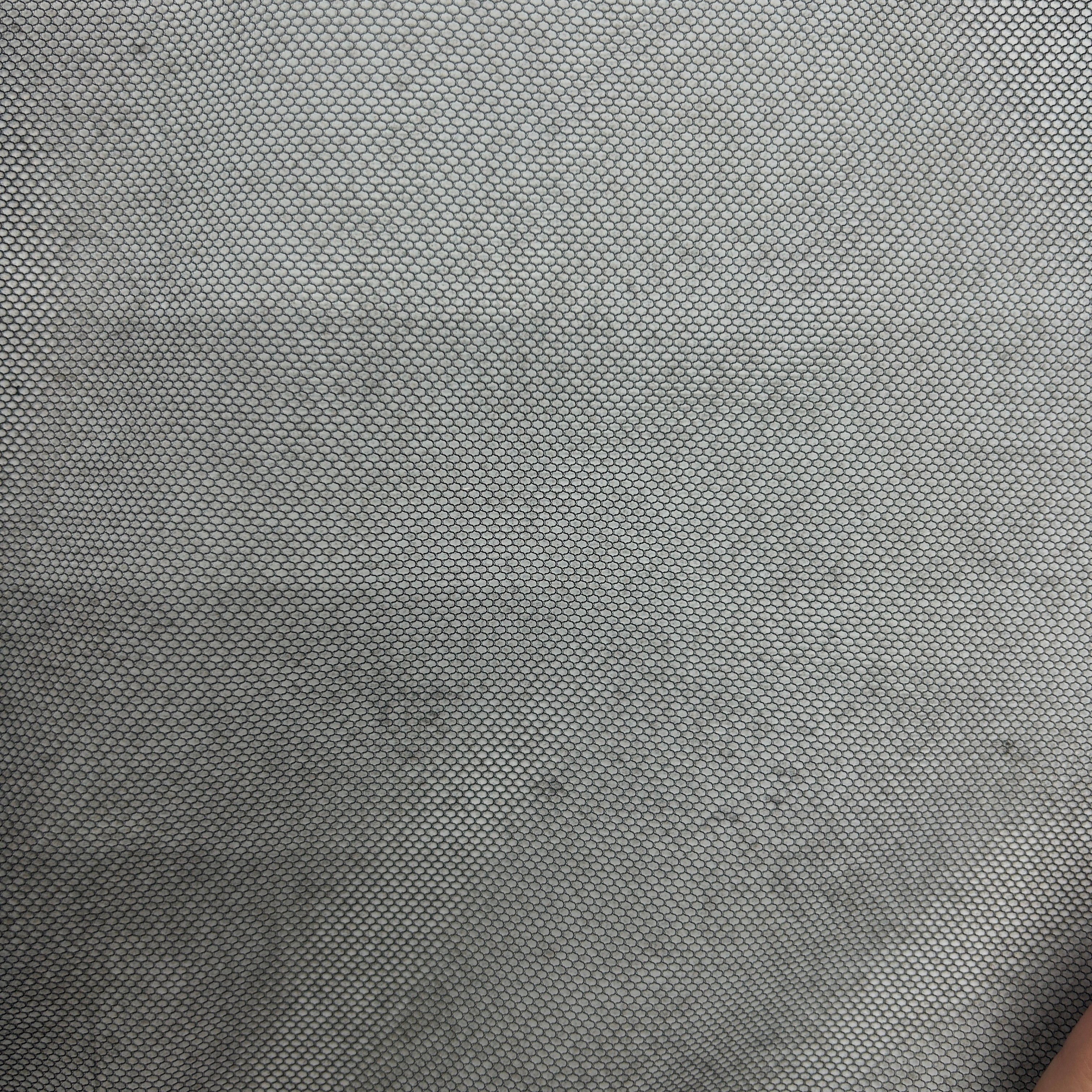 Close-up of lightweight black polyester tulle mesh fabric with a fine open grid-like structure.