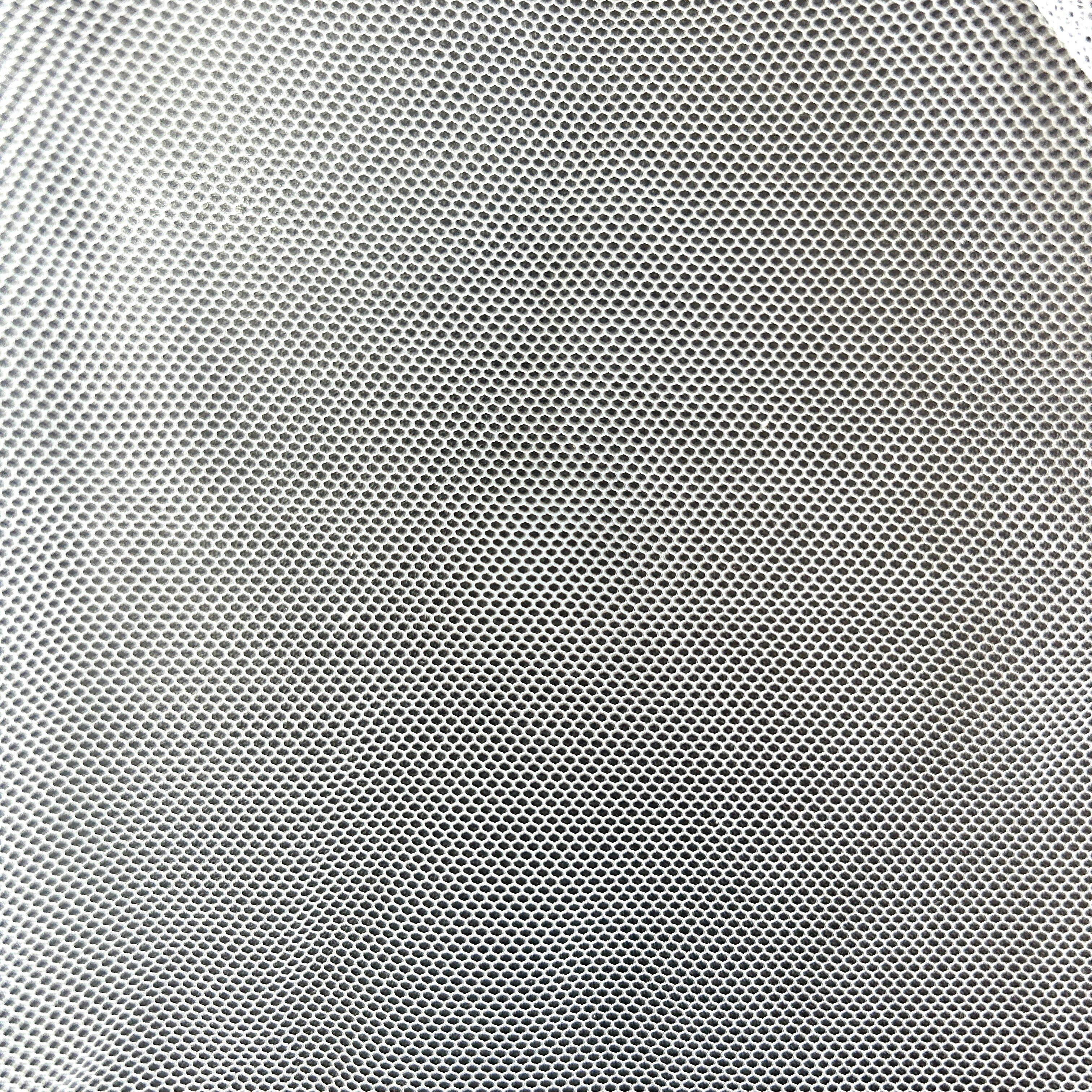Close-up of white polyester tulle mesh fabric with a fine, open grid-like structure.