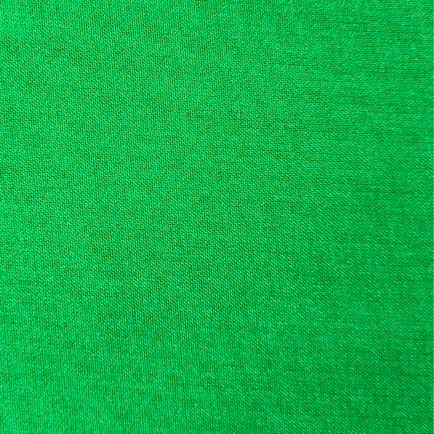 Close-up view of high-quality ultra-thin polyester chiffon fabric in a vibrant green color.
