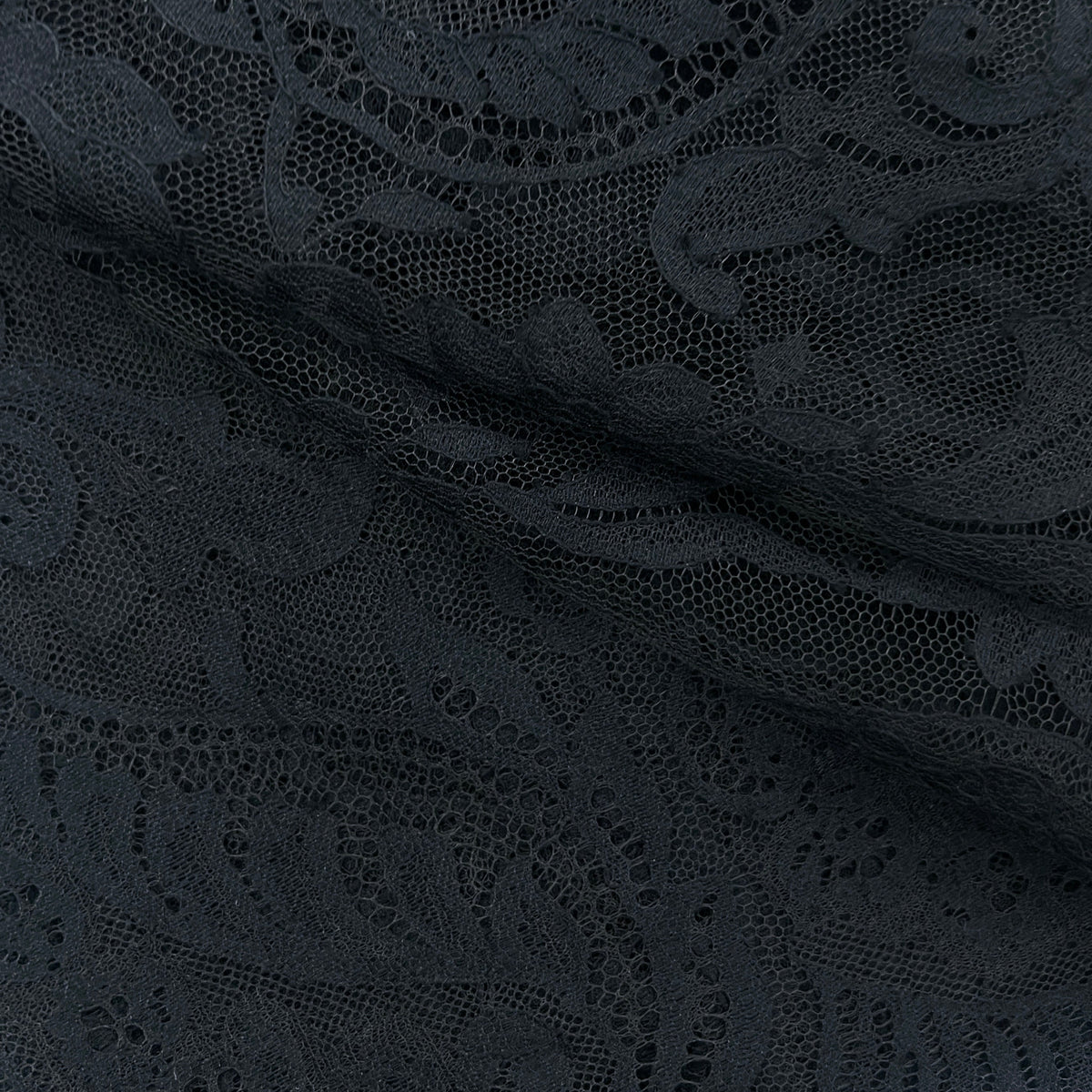 Close-up of dark charcoal gray lace fabric with an intricate floral and paisley pattern.