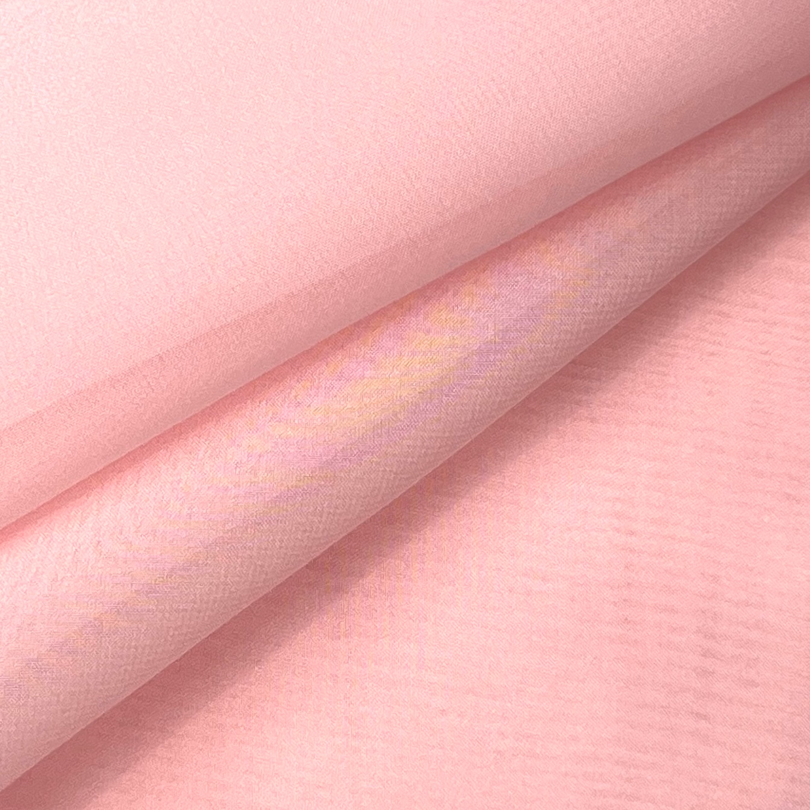Close-up of high-quality ultra-thin pink polyester chiffon fabric with a soft, matte texture.
