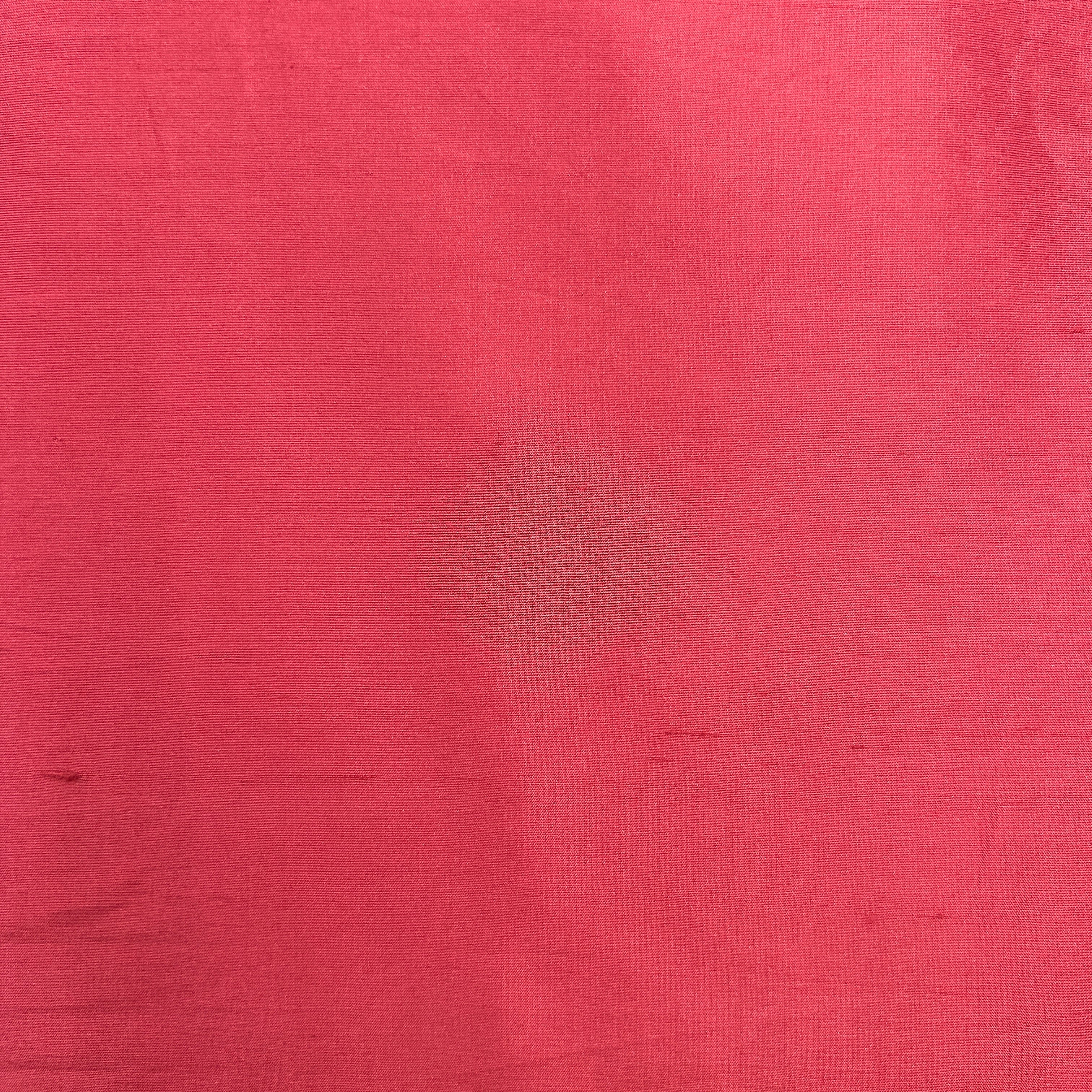 A close-up of a textured pink fabric or material surface filling the frame.
