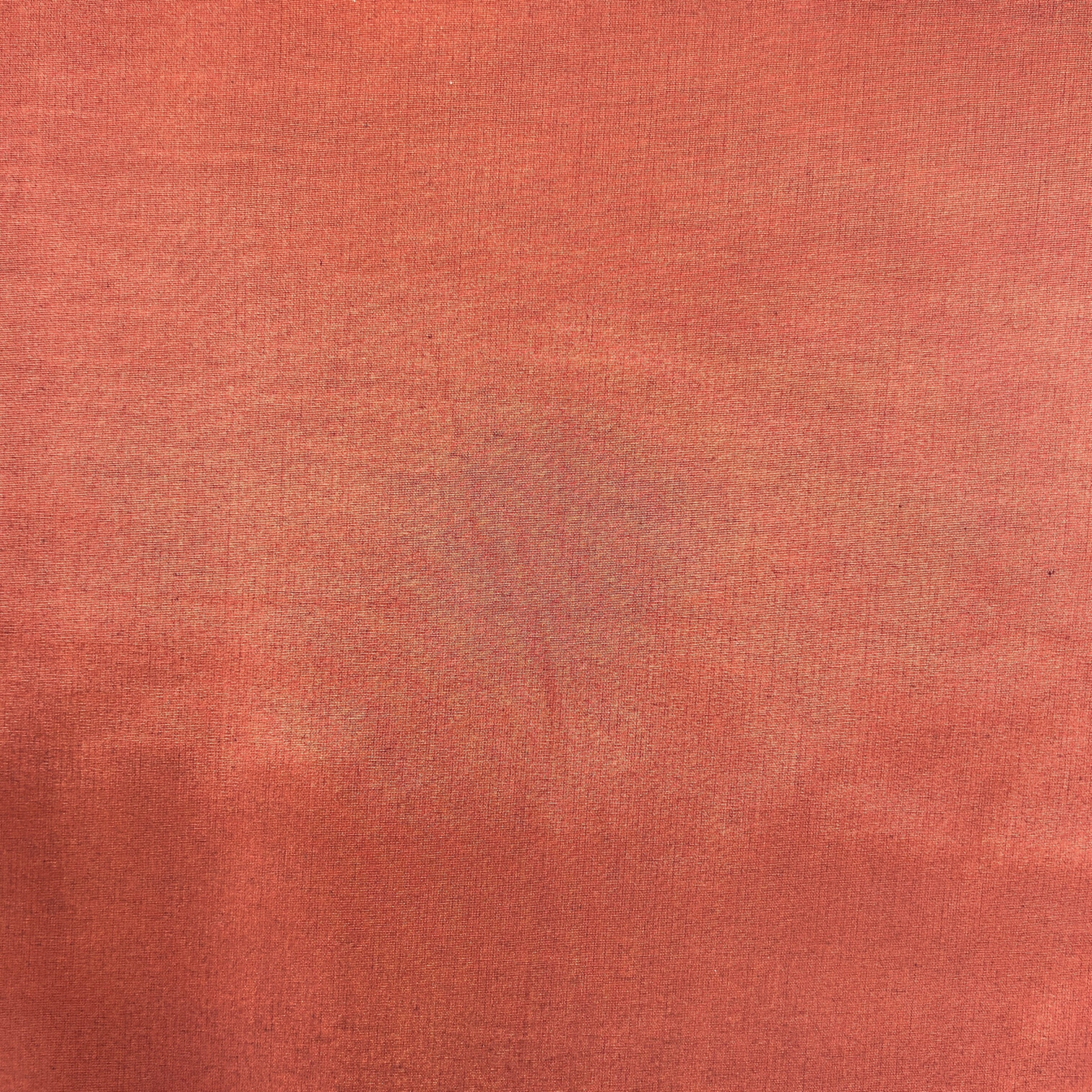A close-up of a textured fabric swatch in a warm terracotta or rust color.