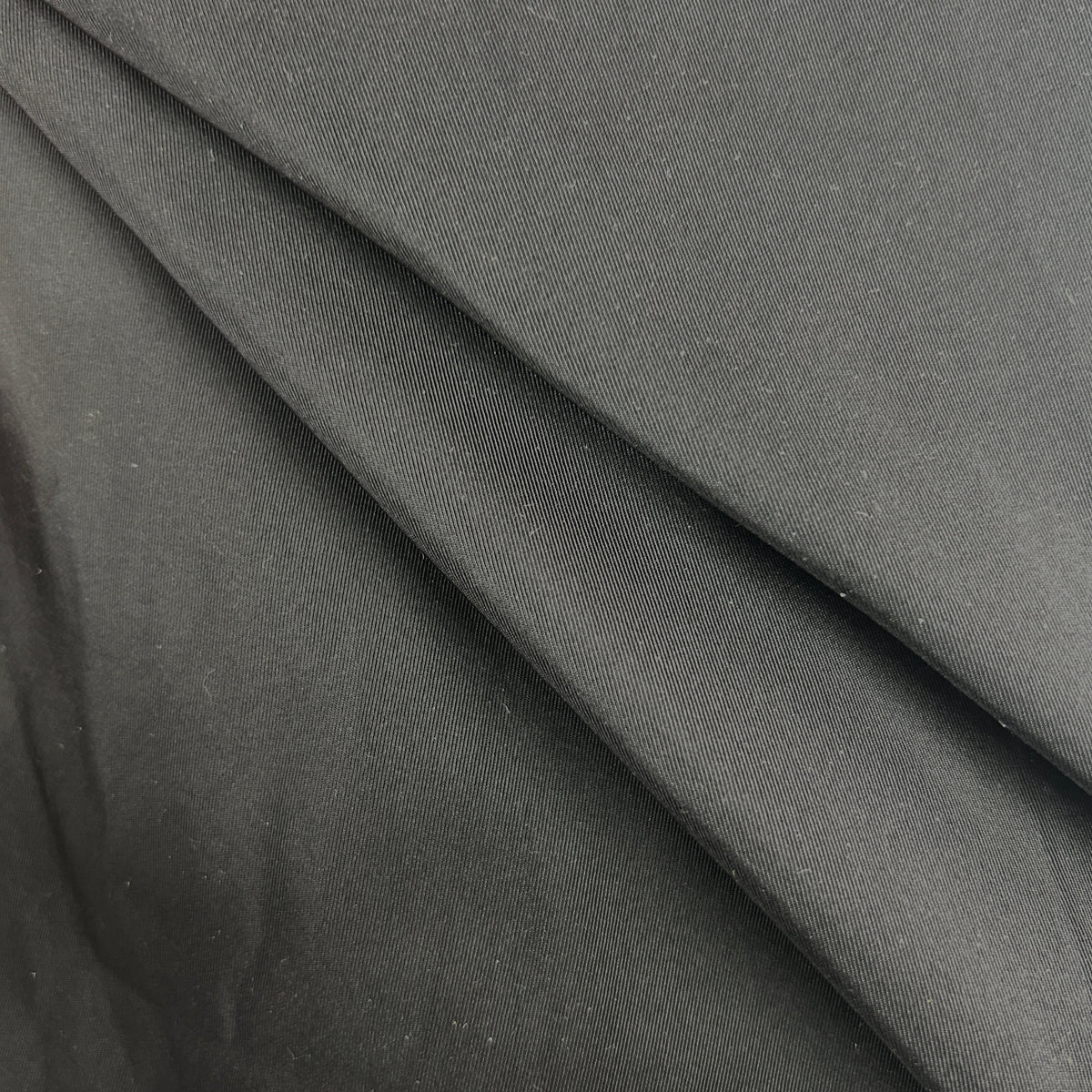 Close-up of black silk grosgrain fabric showing its distinctive ribbed texture and subtle sheen.
