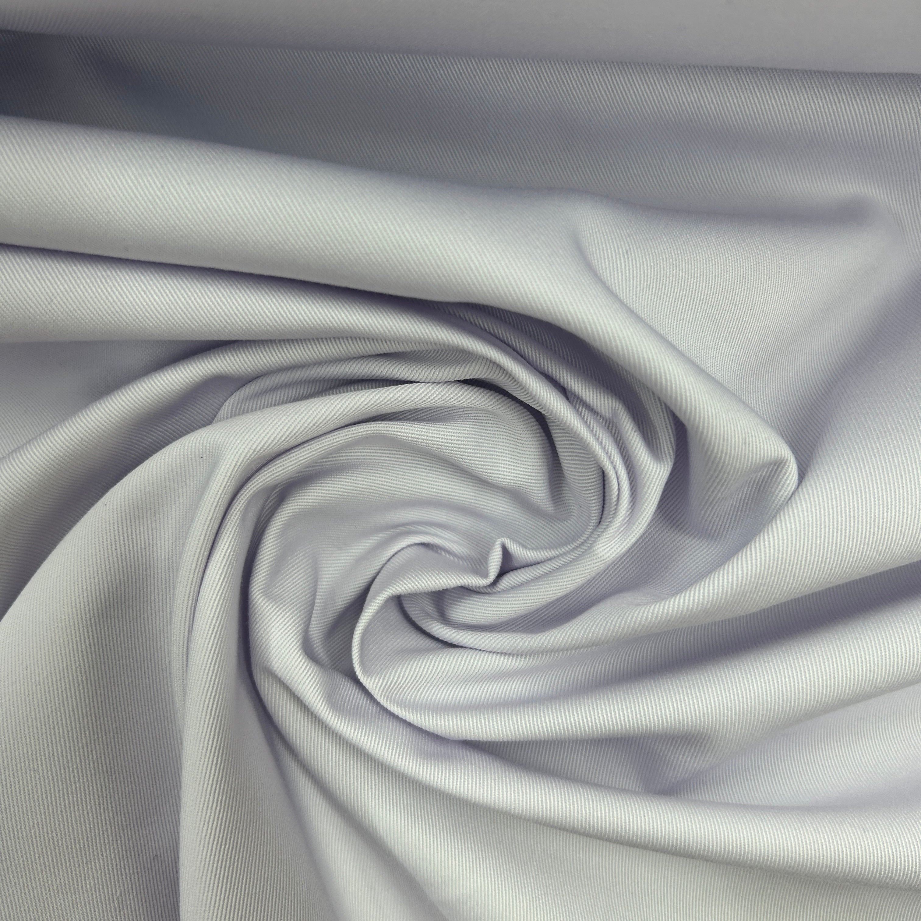 A close-up of light gray fabric arranged in a spiral drape, showing the material texture and soft folds.