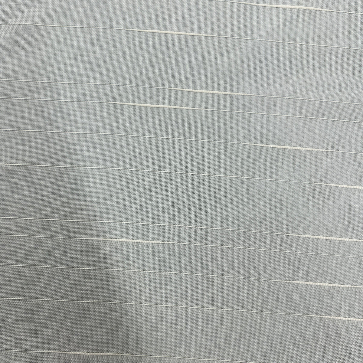 A close-up of a light gray woven fabric with thin, horizontal off-white stripes running across it.