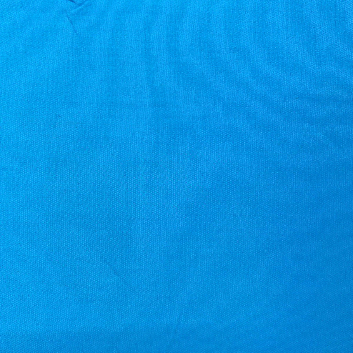 A close-up of a bright blue fabric texture filling the frame.