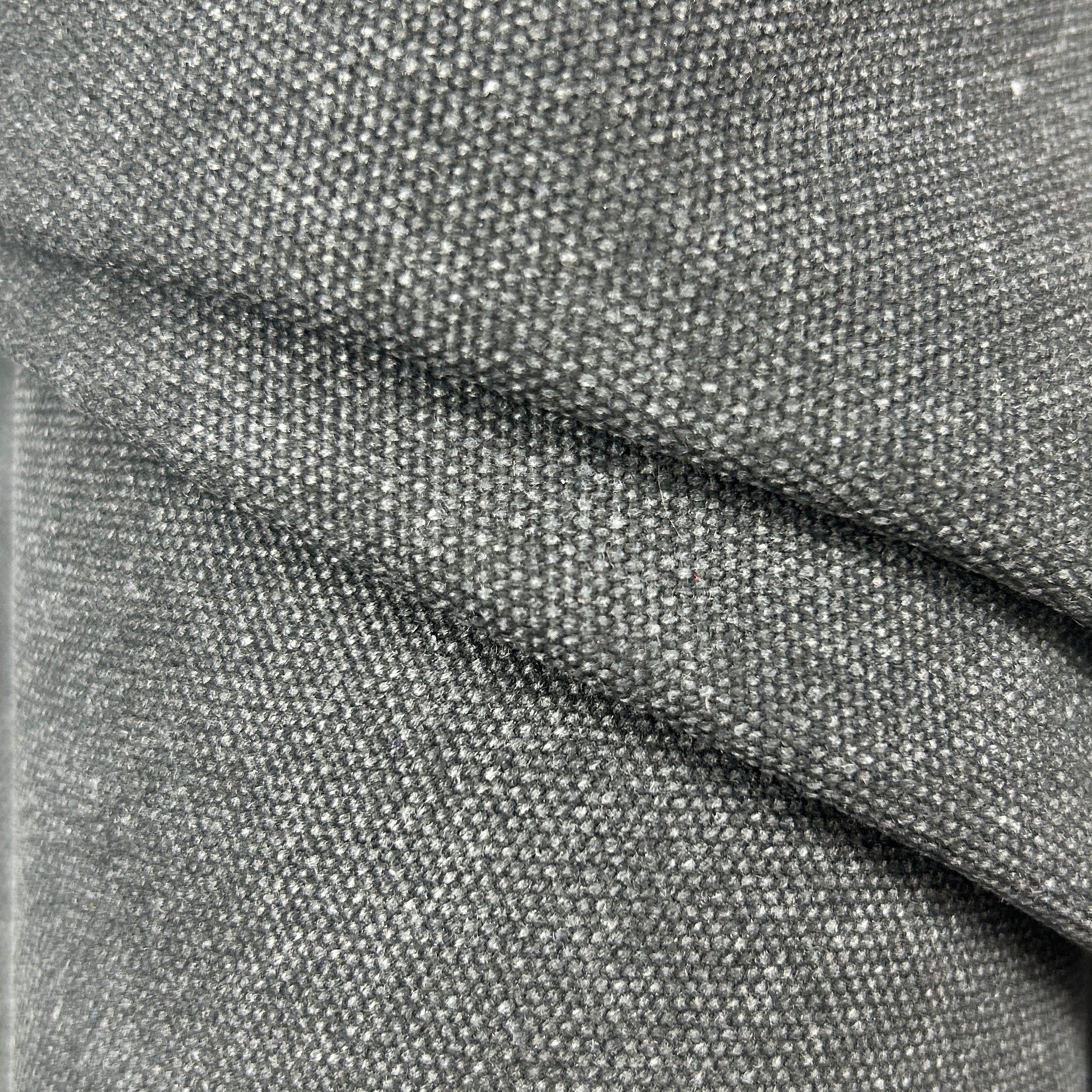Close-up of black poly cotton heavy waxed canvas fabric with a stiff, textured weave.