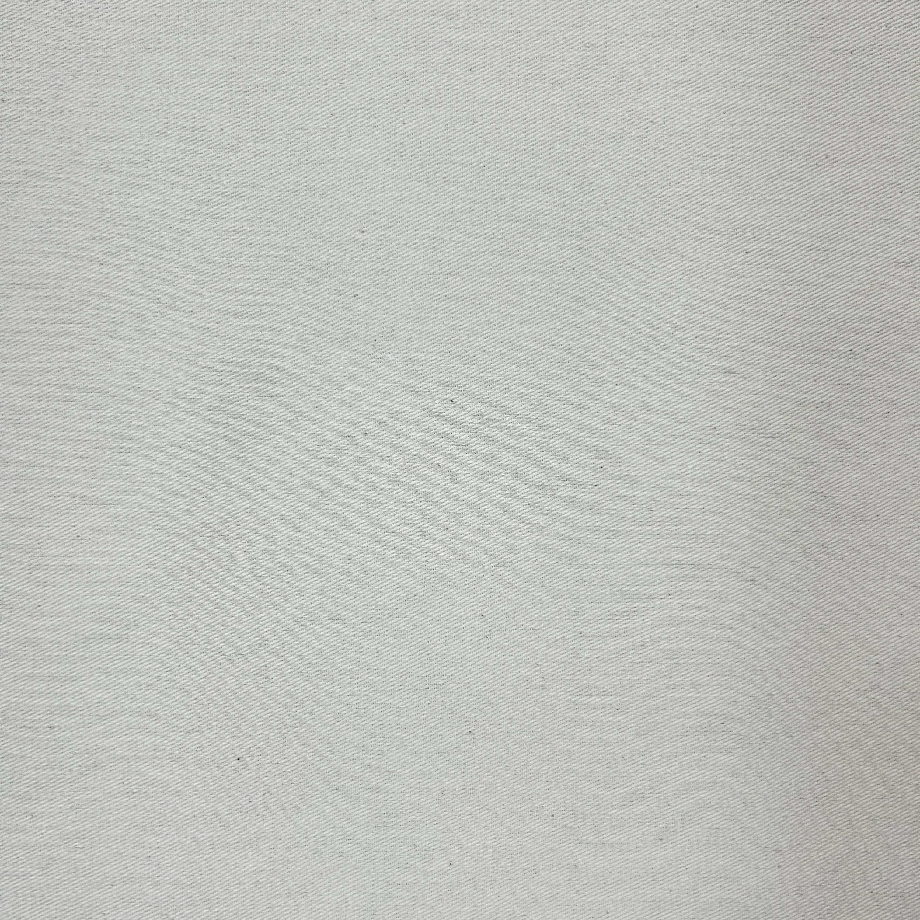Close-up of natural white plain calico canvas heavy fabric showing its rustic diagonal weave.