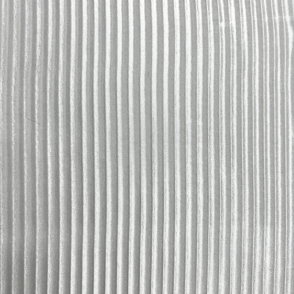 A close-up of a light gray pleated fabric texture with vertical folds.