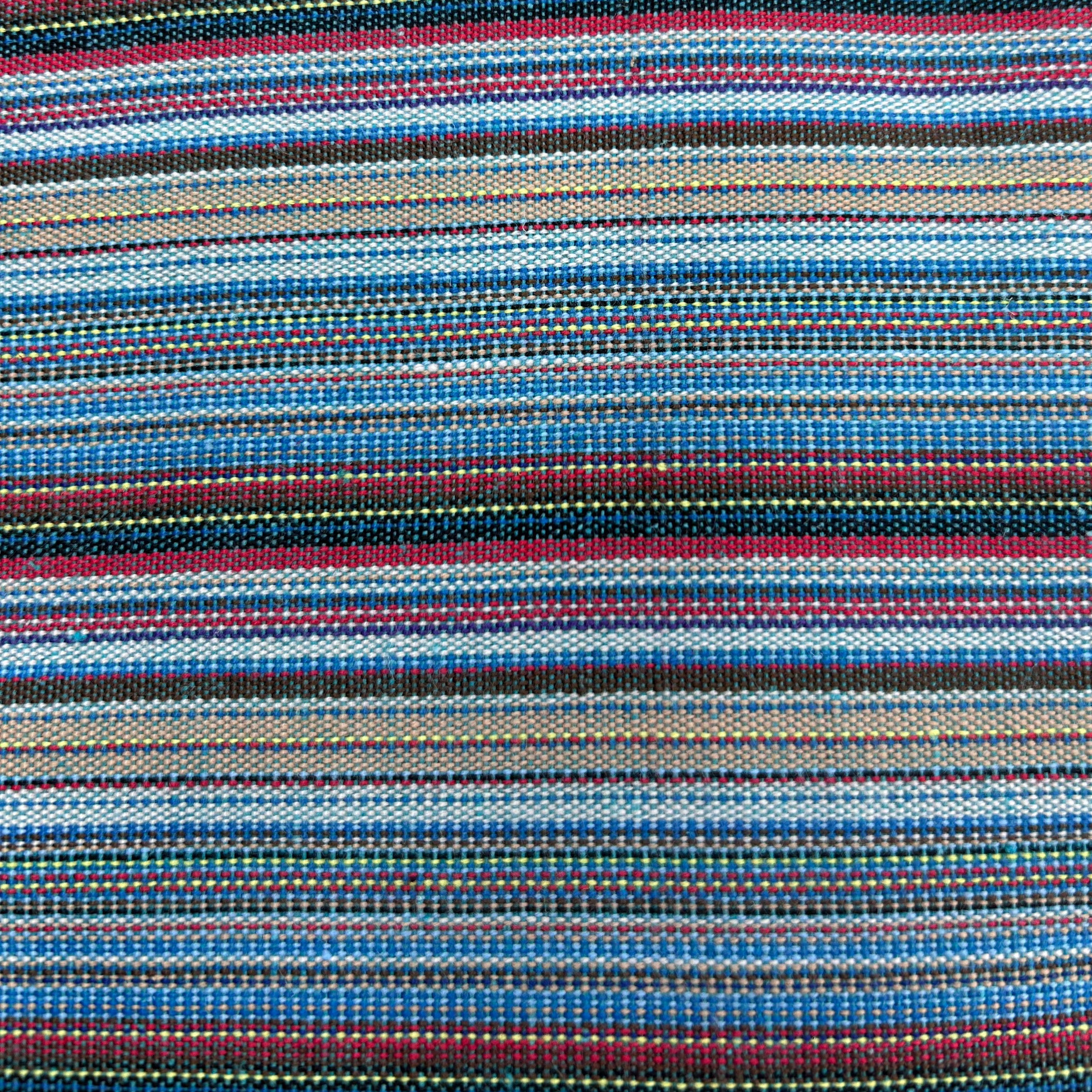 Close-up view of jacquard striped polyester fabric with intricate woven-in stripe patterns in multicolour pink and blue.