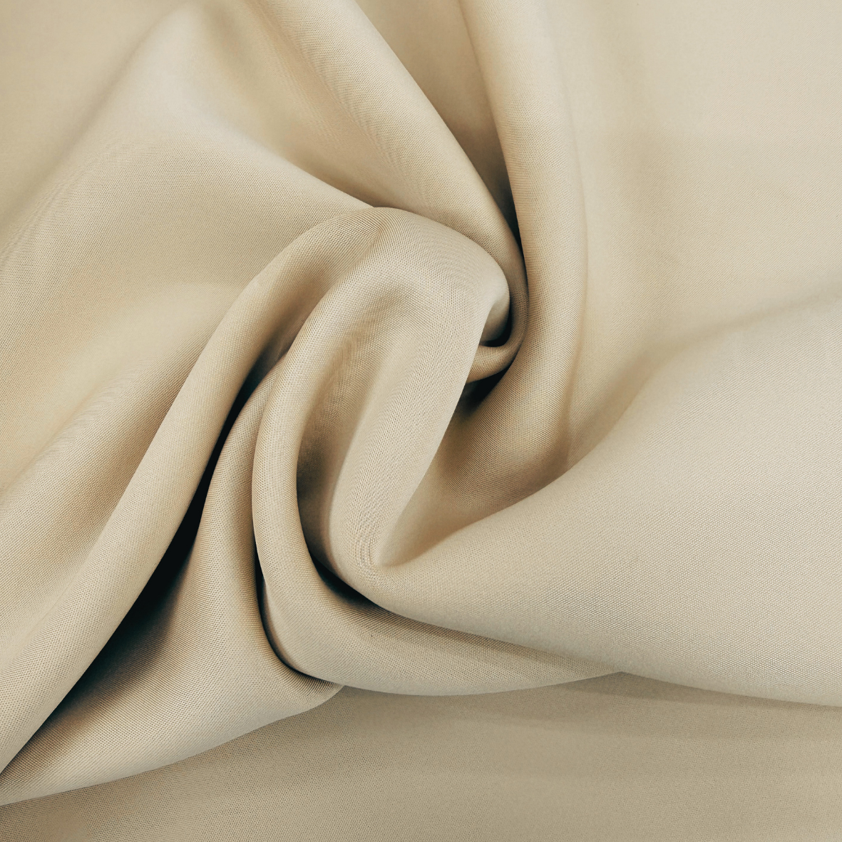 A close-up of draped beige fabric with soft folds and a smooth texture filling the frame.