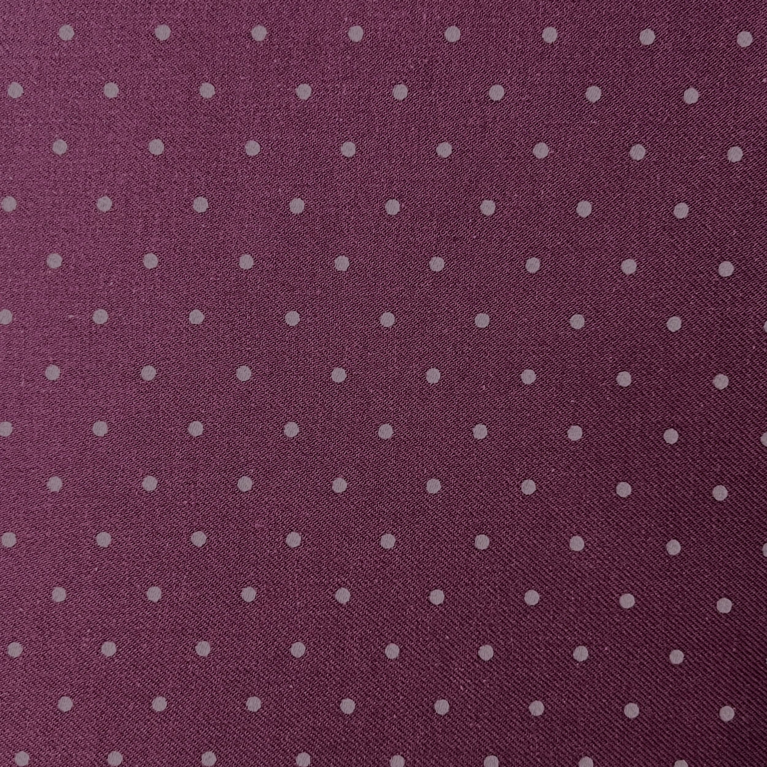 Patterned fabric with small white dots on a purple background