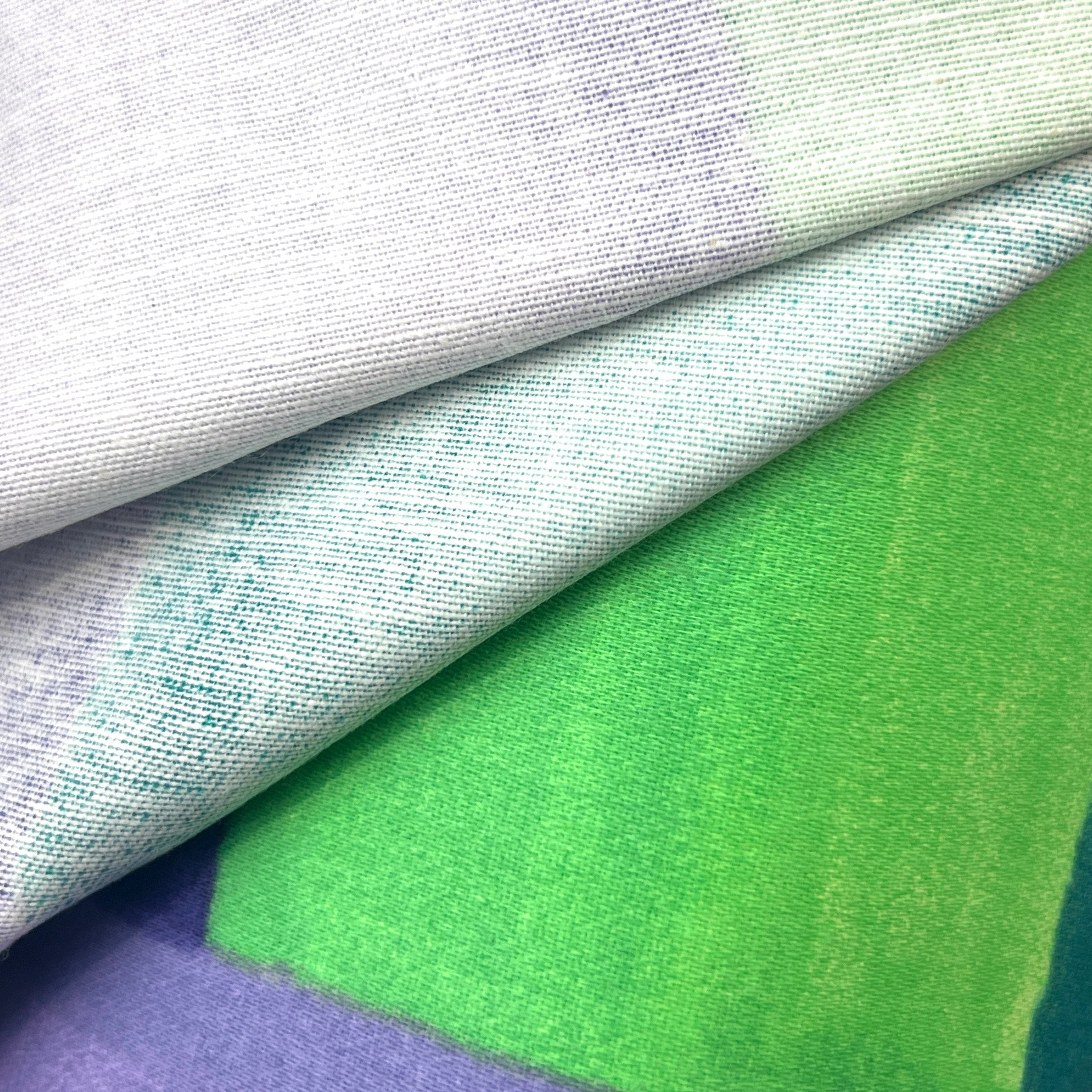 Close-up of various fabric textures in green, purple, and gray.