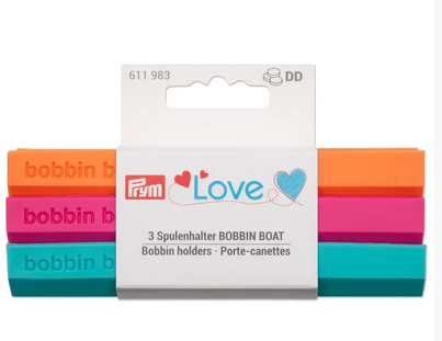 Three colorful bobbin holders in orange, pink, and mint green.