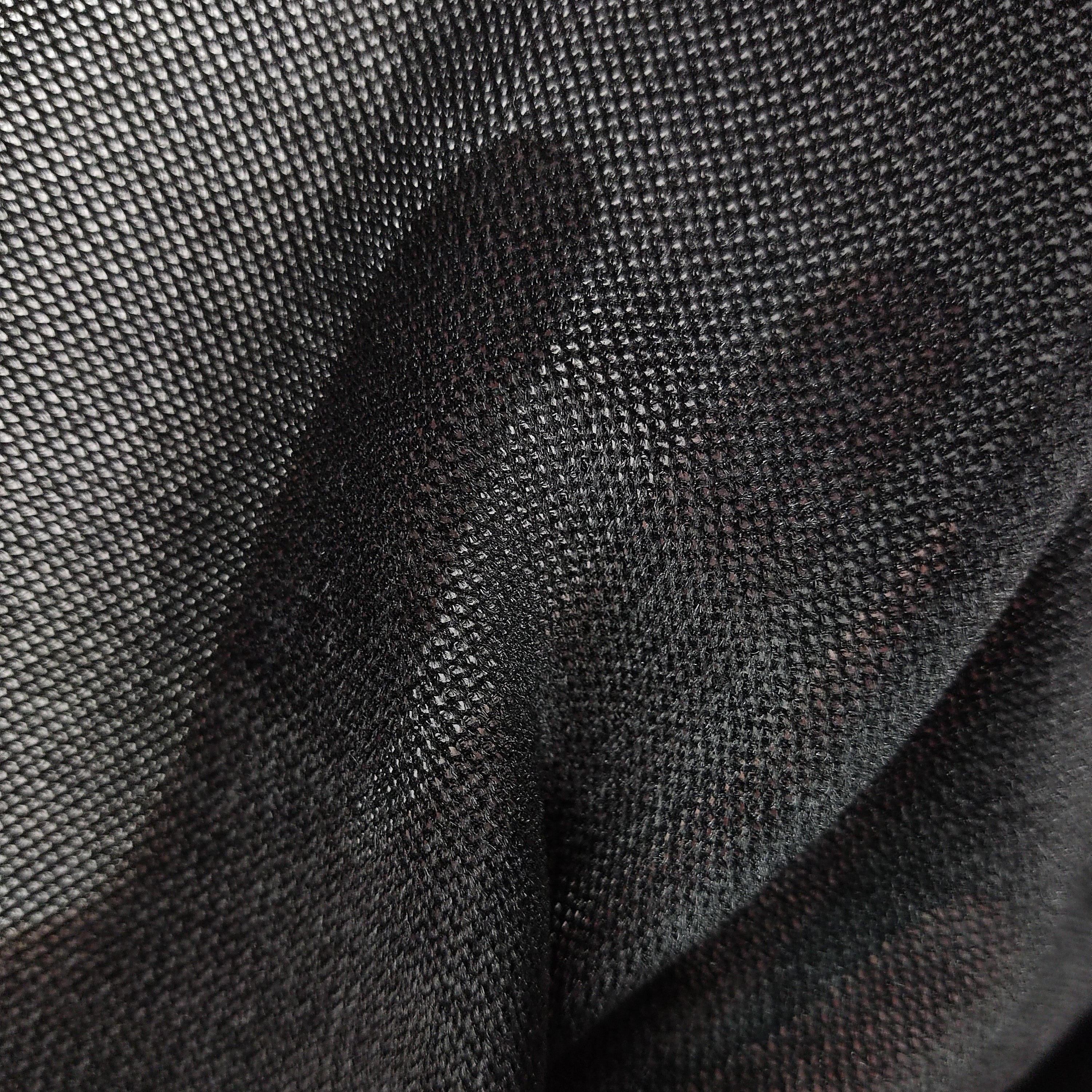 Close-up of black velvet tulle mesh fabric with a fine flocked texture and sheer drape.