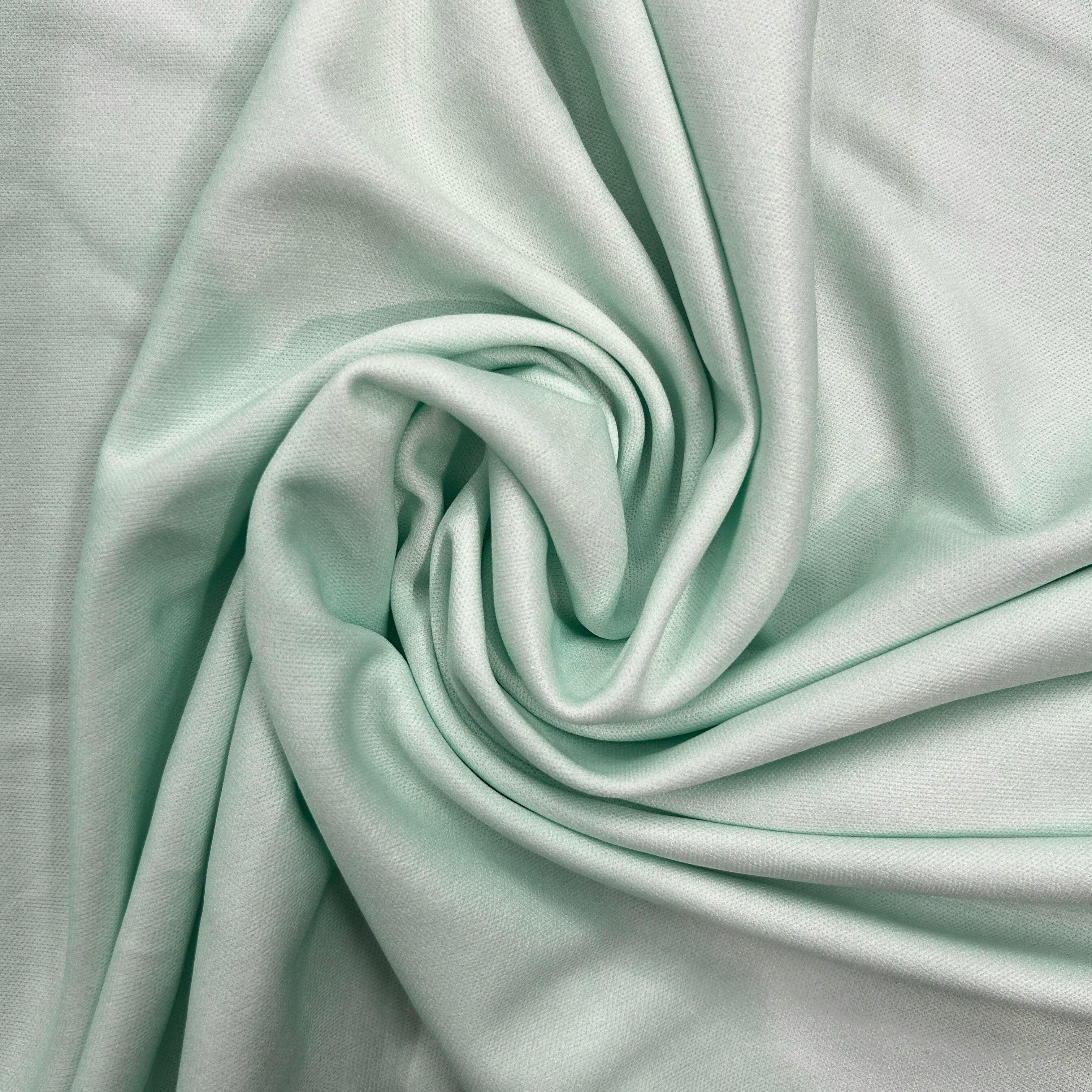 Close-up of light green fabric with folds